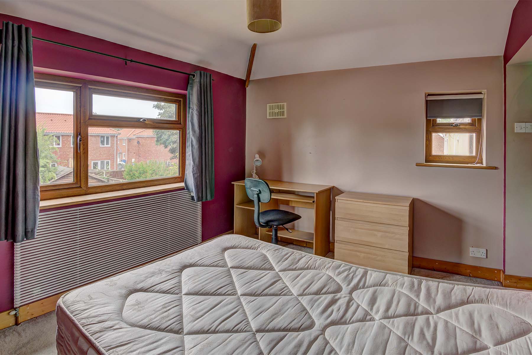 Double bedroom with bed, chest of drawers, and desk.