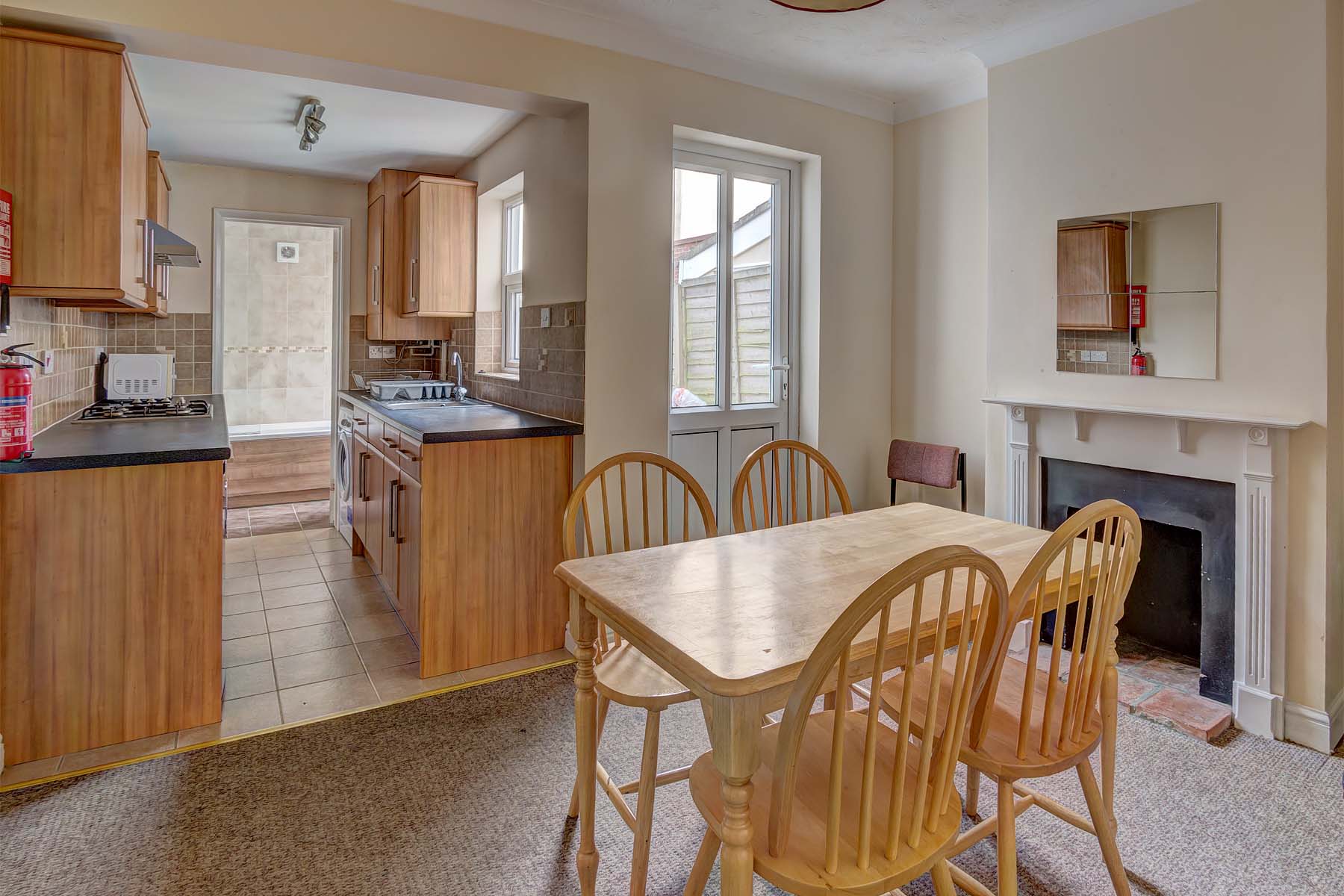 Dining room with wooden dining table and decorative fireplace.