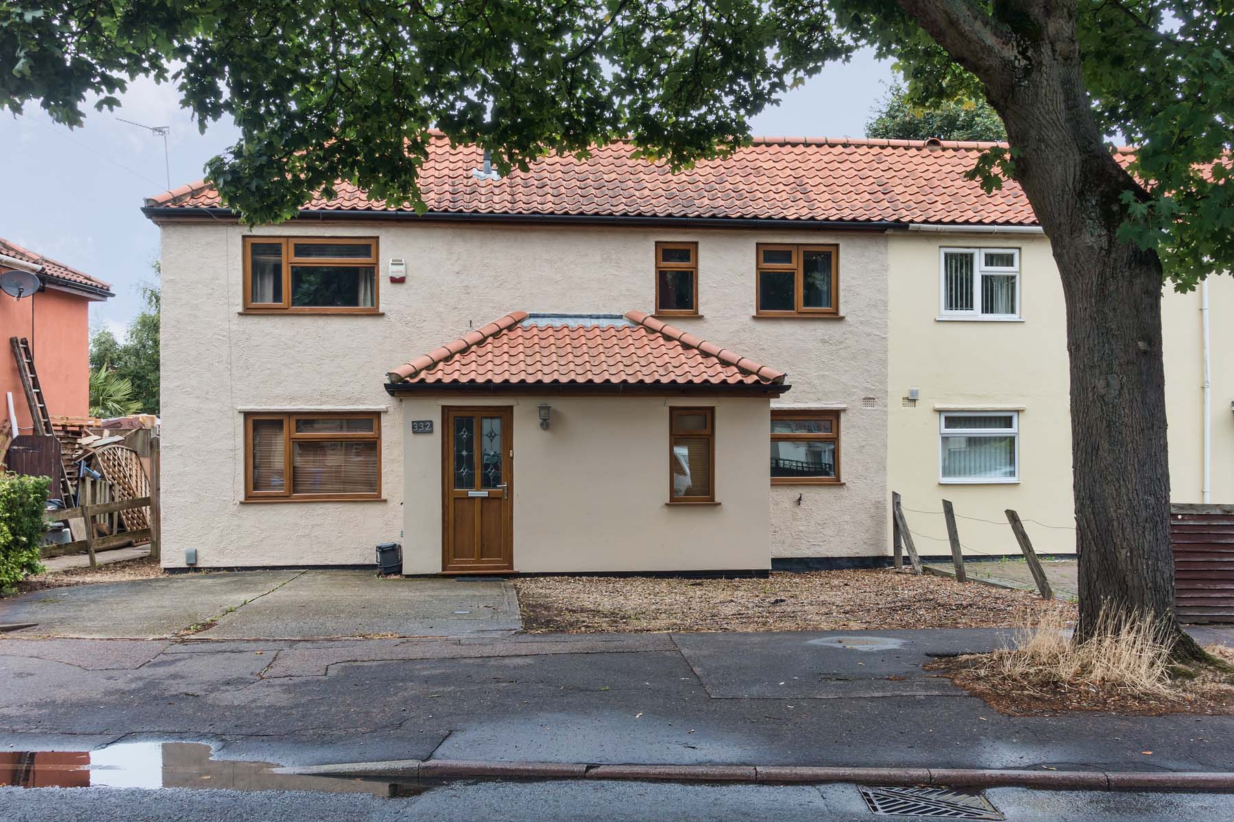 Cream house with porch and concrete driveway