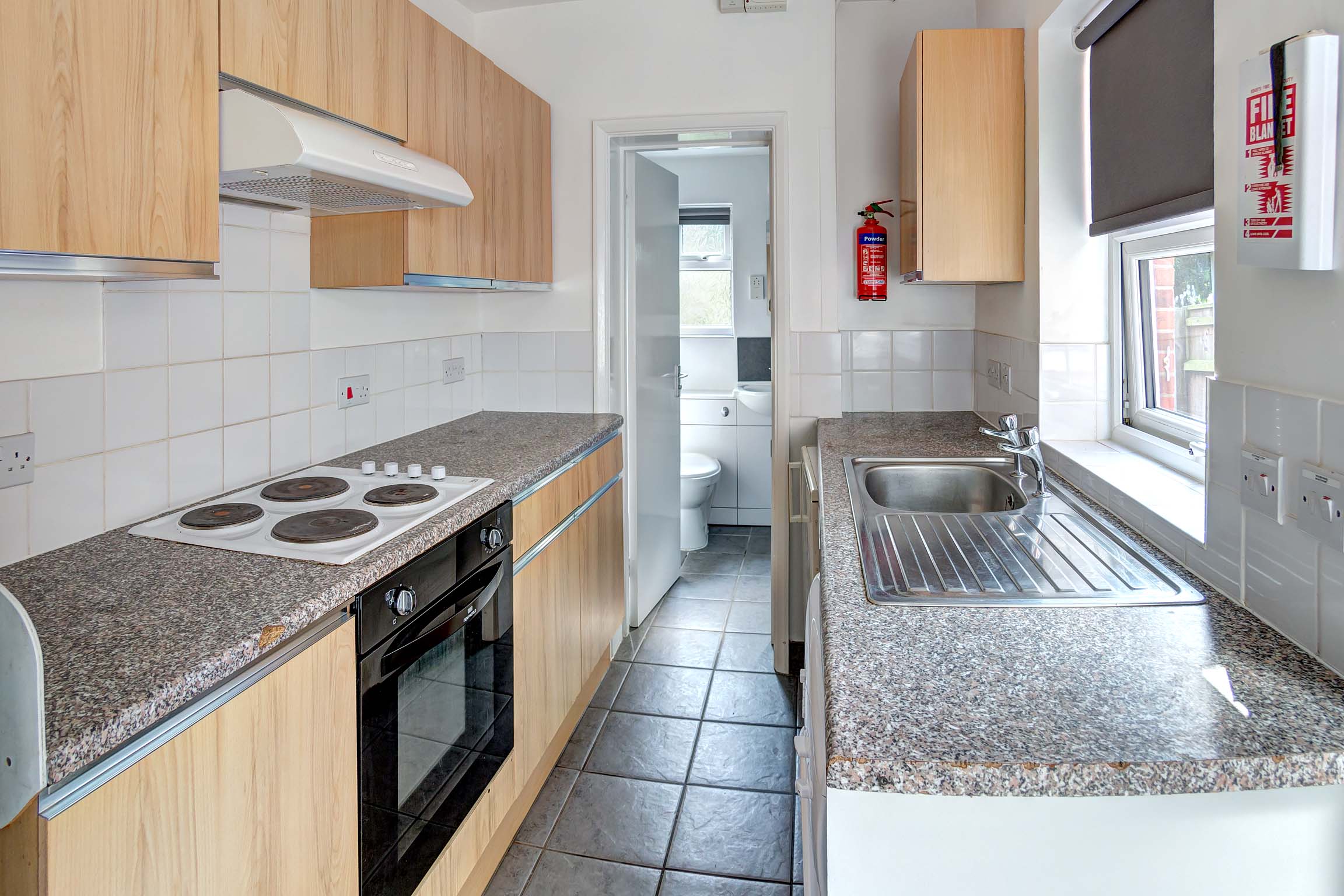 Galley style kitchen with fitted, wooden cupboards.