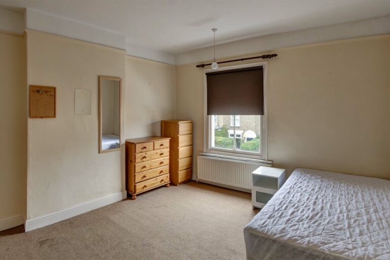 Large bedroom with double bed and wooden furnishings