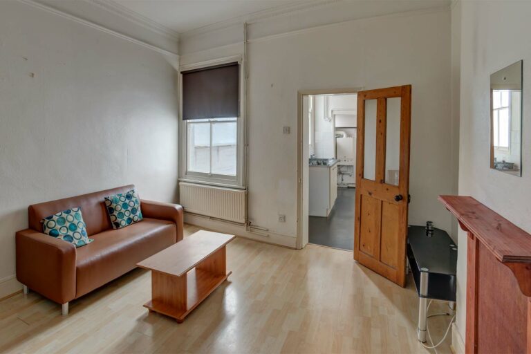 Living room, leading to kitchen, with sofas