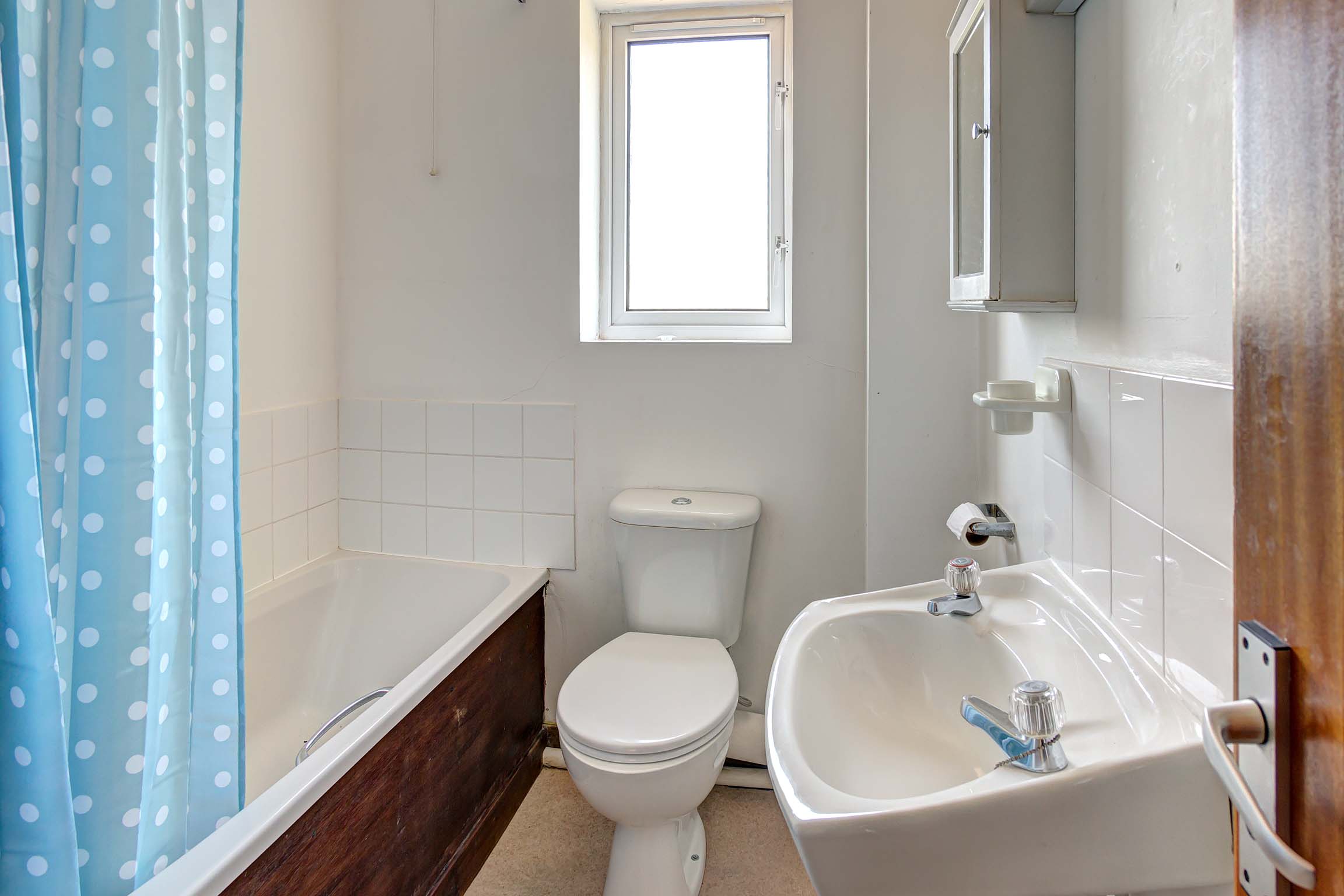 Bathroom with shower over bath, toilet, and sink