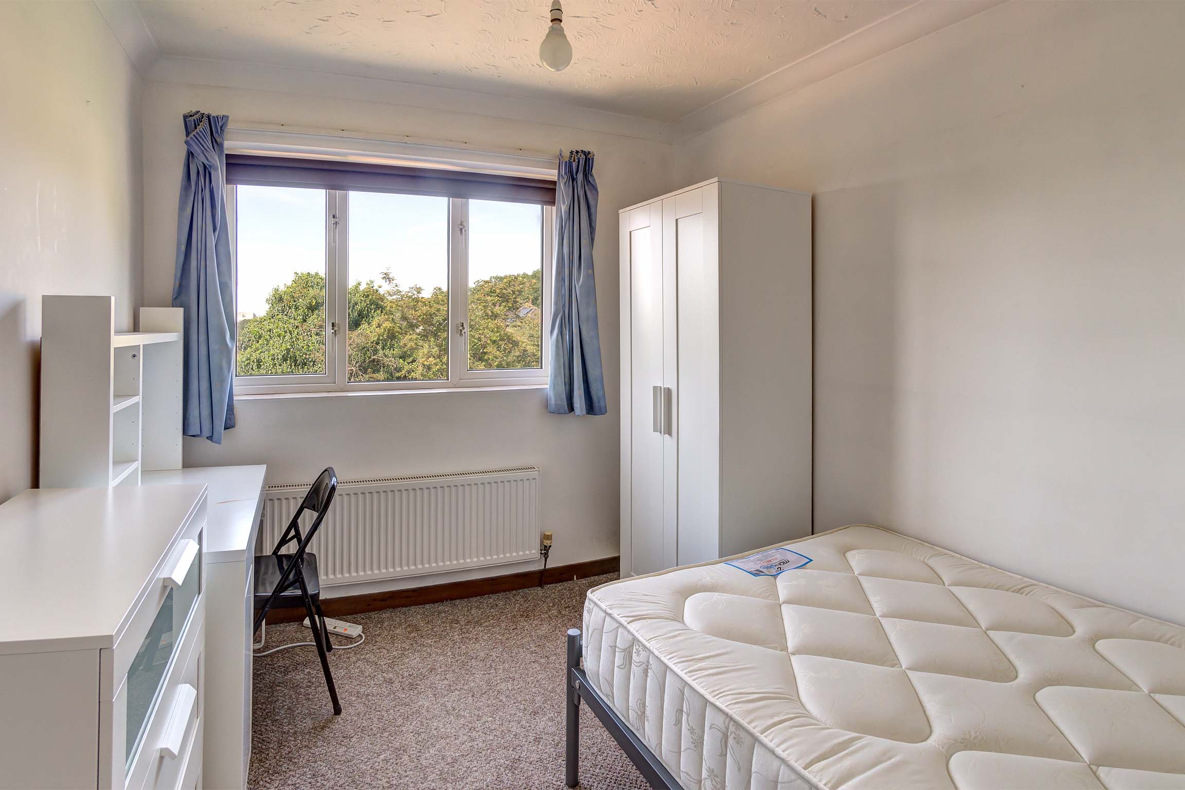 Bedroom with double bed and white furnishings