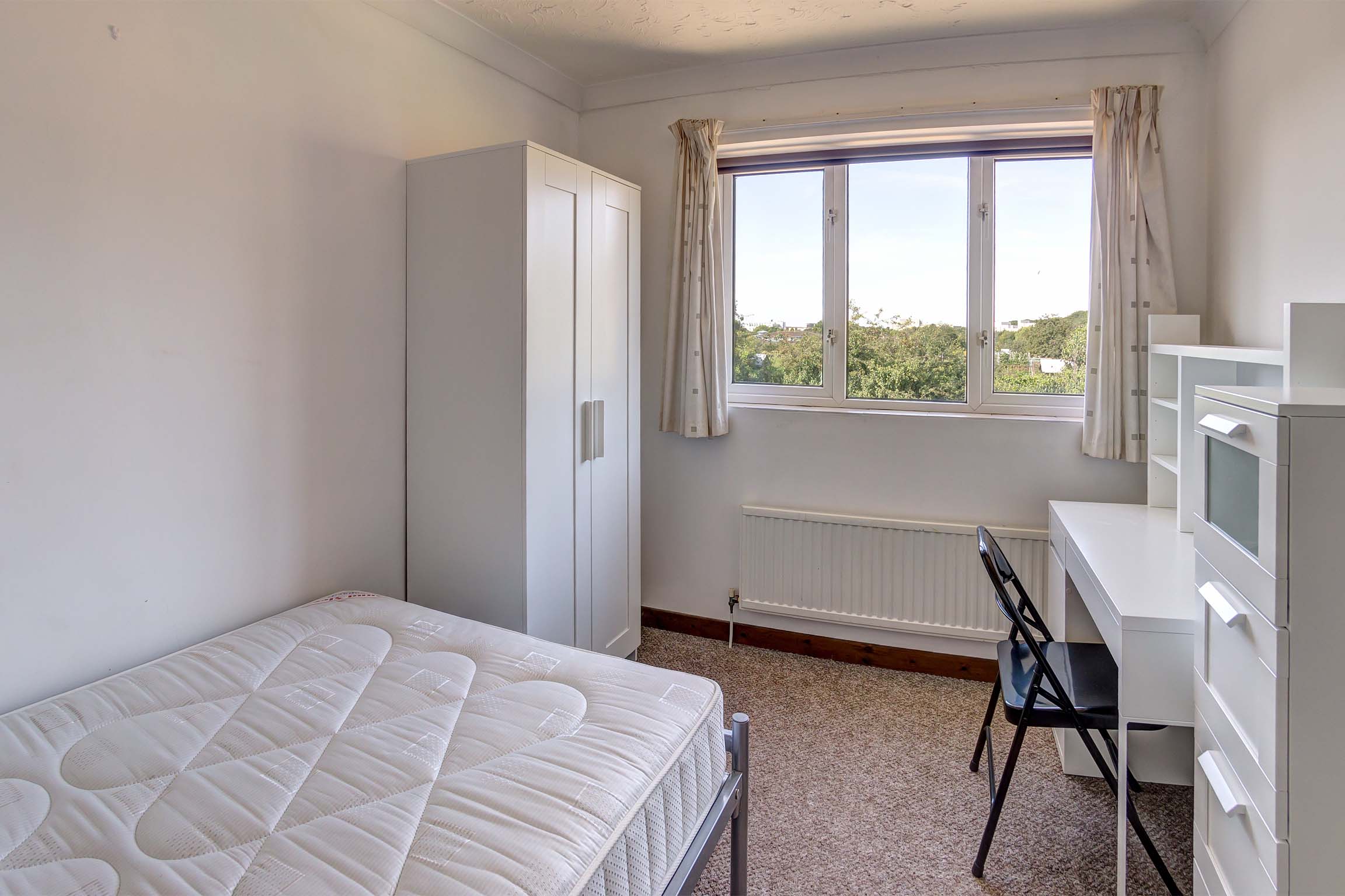 Bedroom with double bed and white furnishings