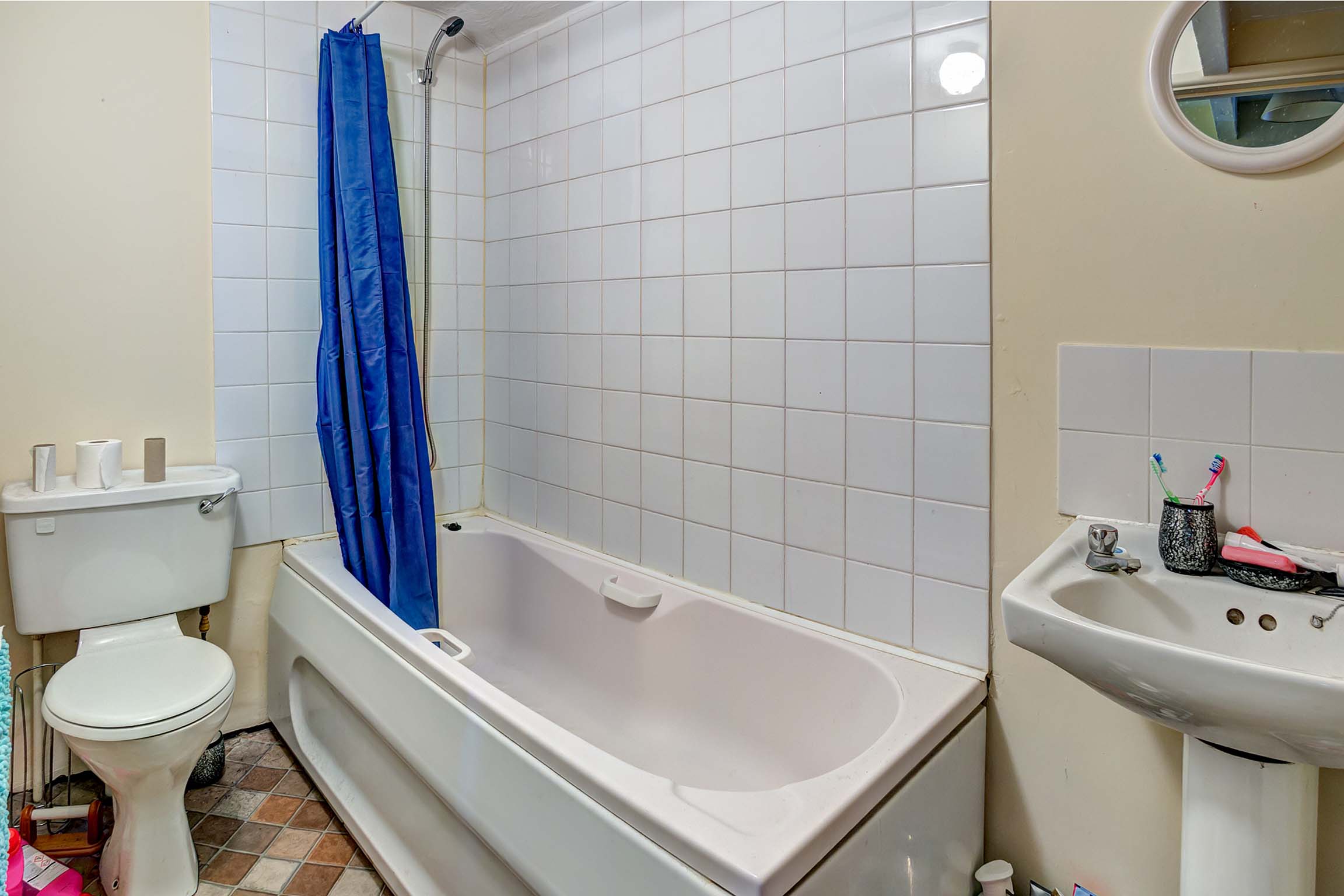 Bathroom with shower over bath, sink, and toilet