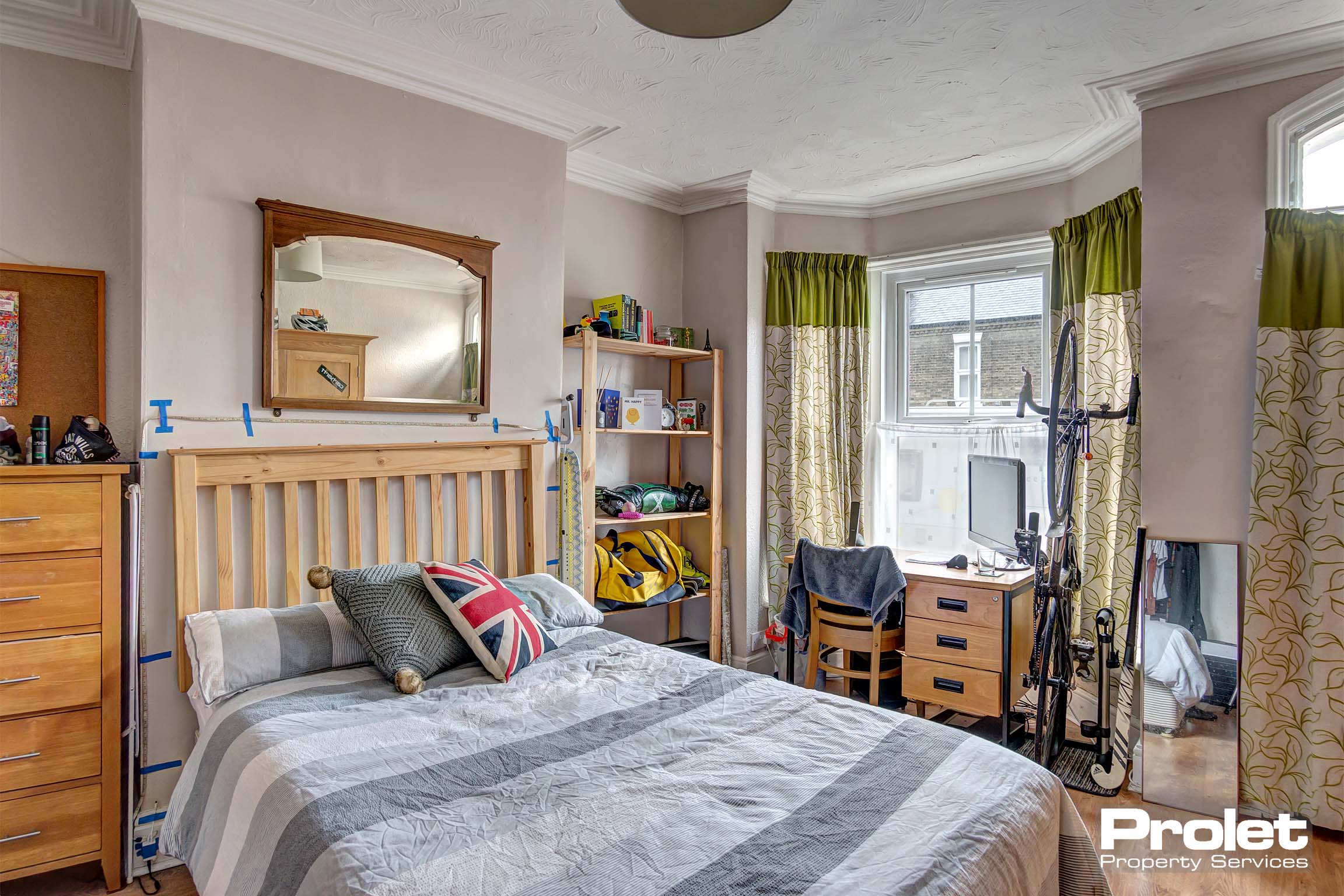 Downstairs bedroom with front door entrance, bay window, double bed and desk