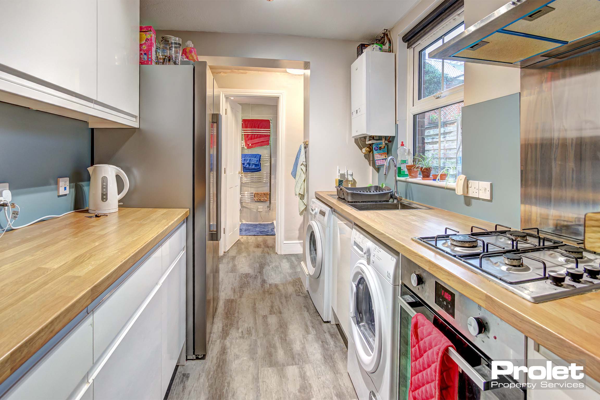 Modern kitchen with wood effect worktops, and white cabinets