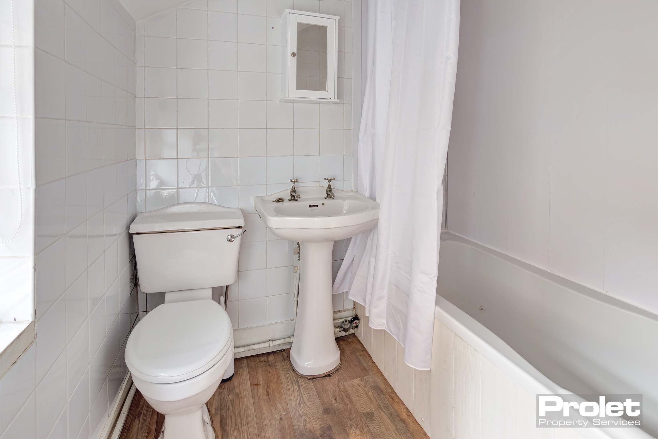 Bathroom with shower over bath, toilet, and sink