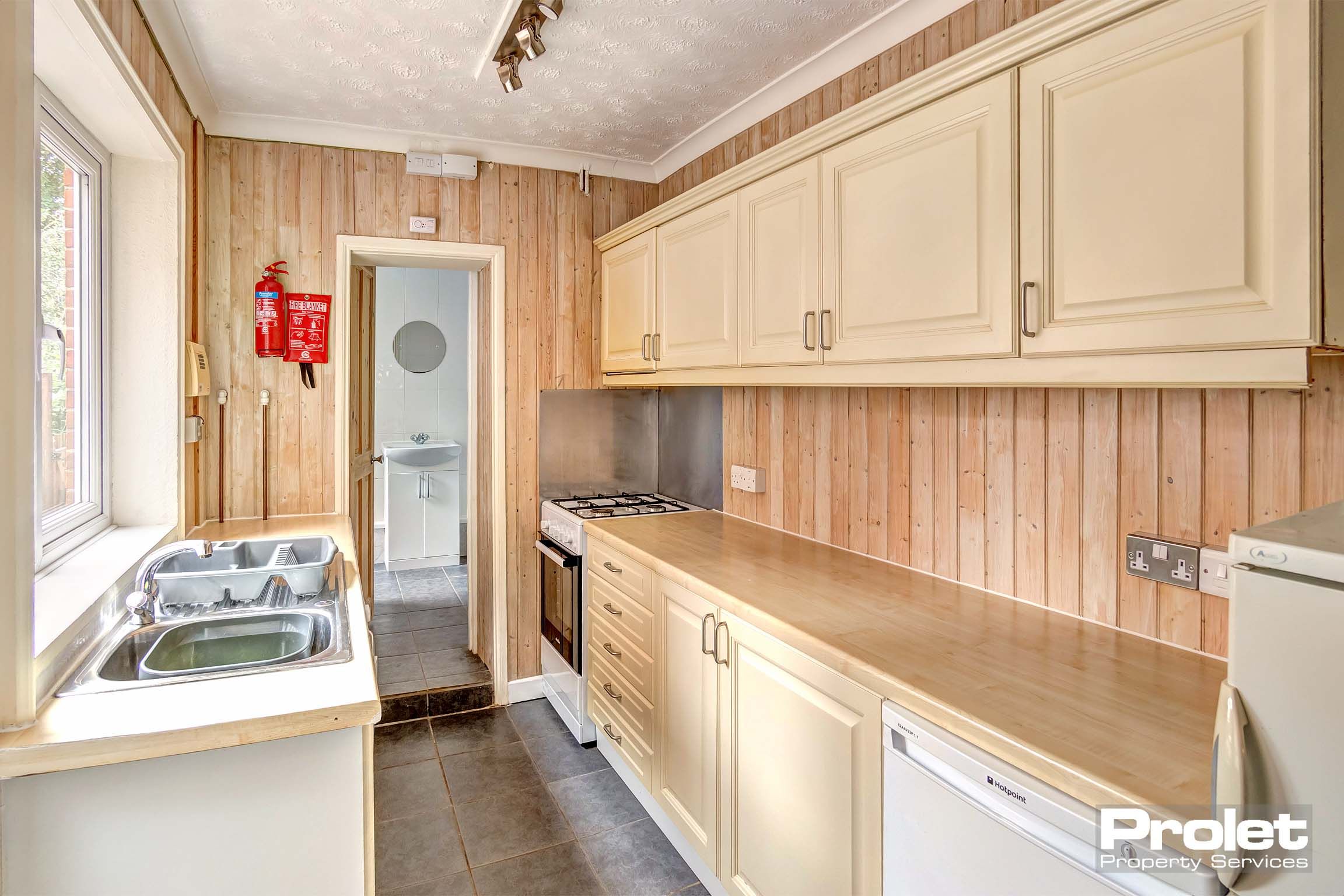 Kitchen with cream cabinets, and white goods