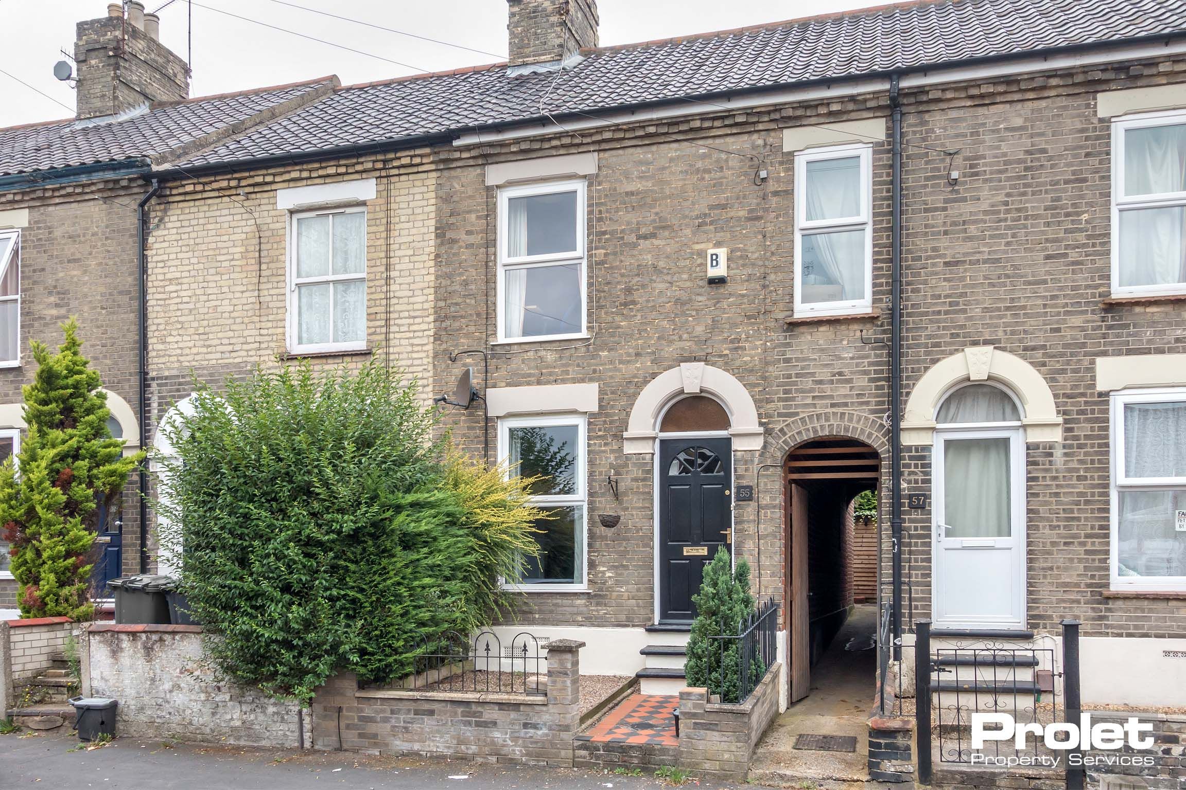 Grey brick terraced house with side access