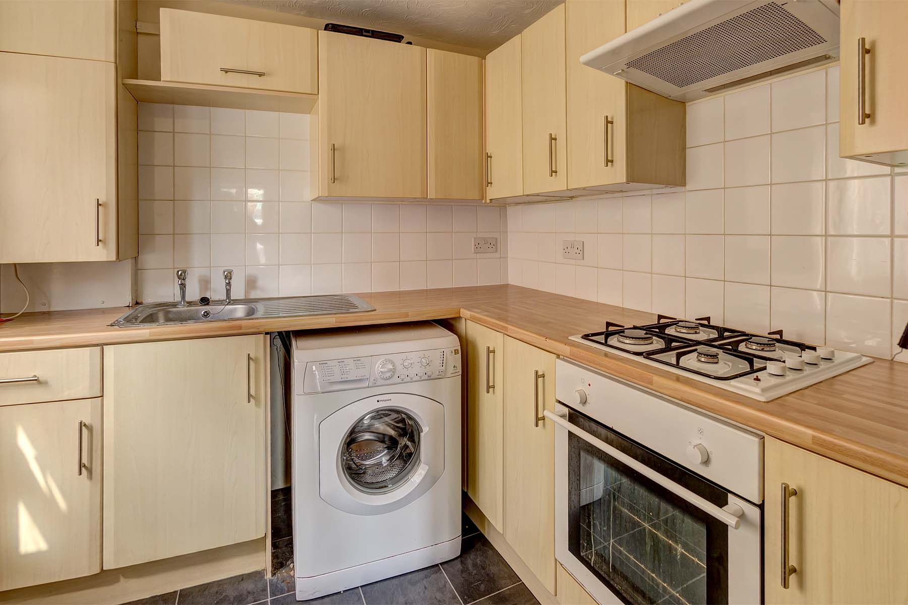 Kitchen with pine effect cabinets and worktop with white goods