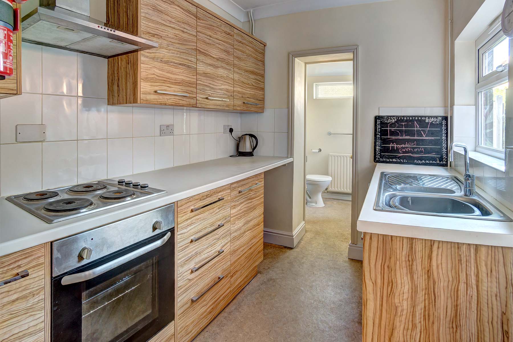 Galley kitchen with white worktops and modern wood effect cupboards