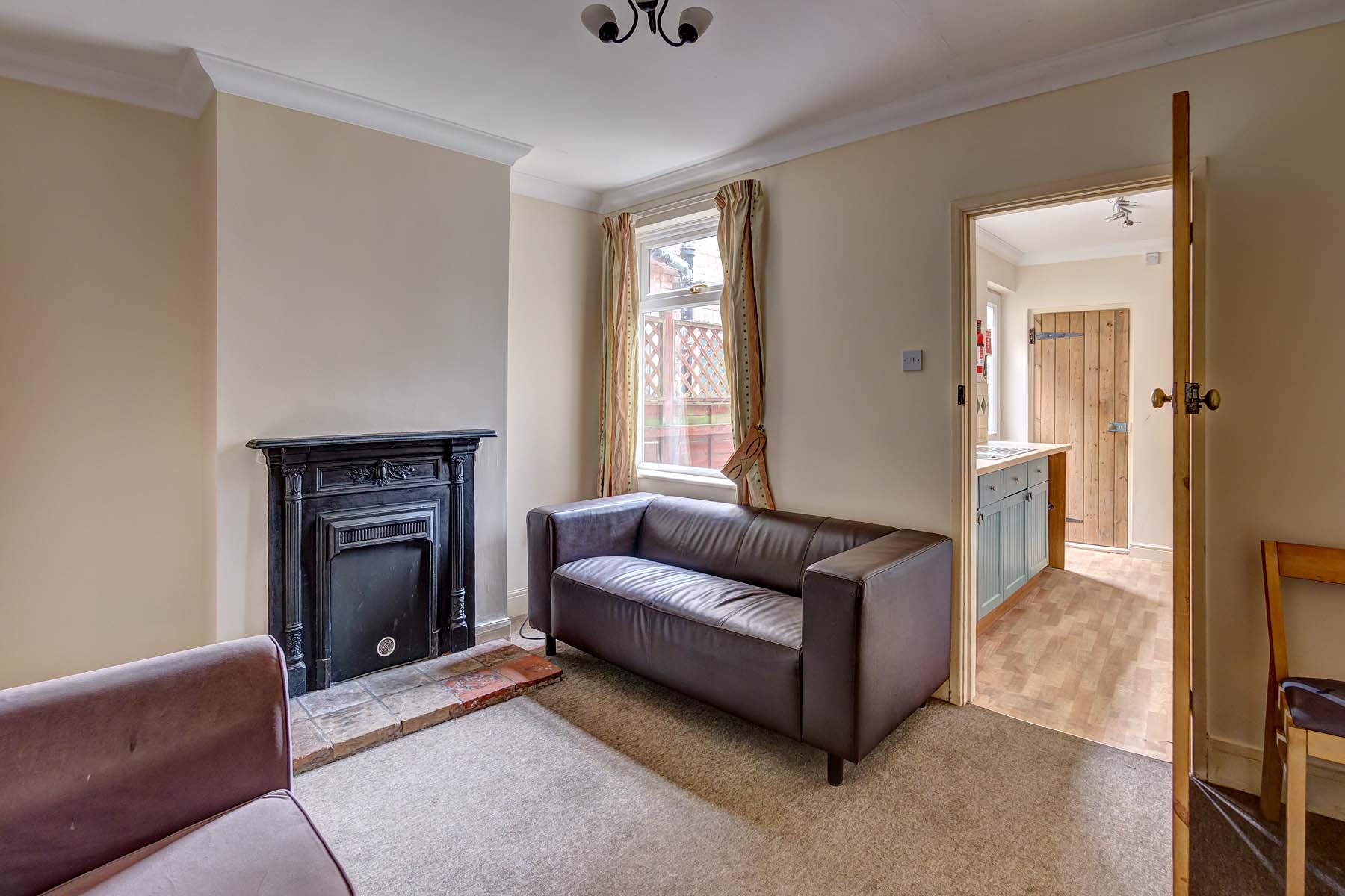 Living room with leather effect sofas and period fireplace