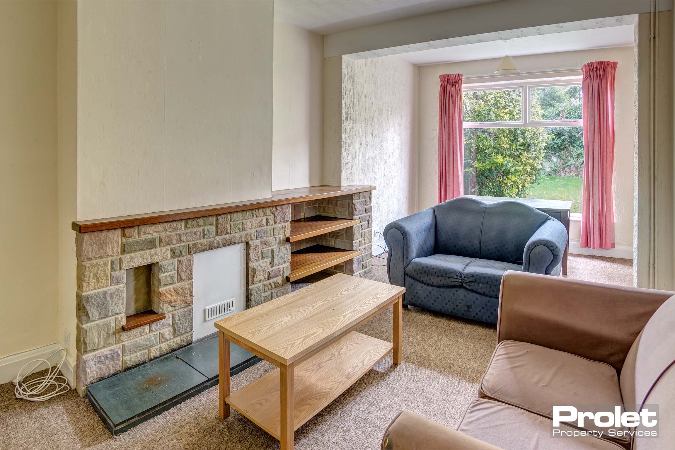 Lounge area with decorative fireplace, a brown leather sofa, a black leather sofa and a coffee table.