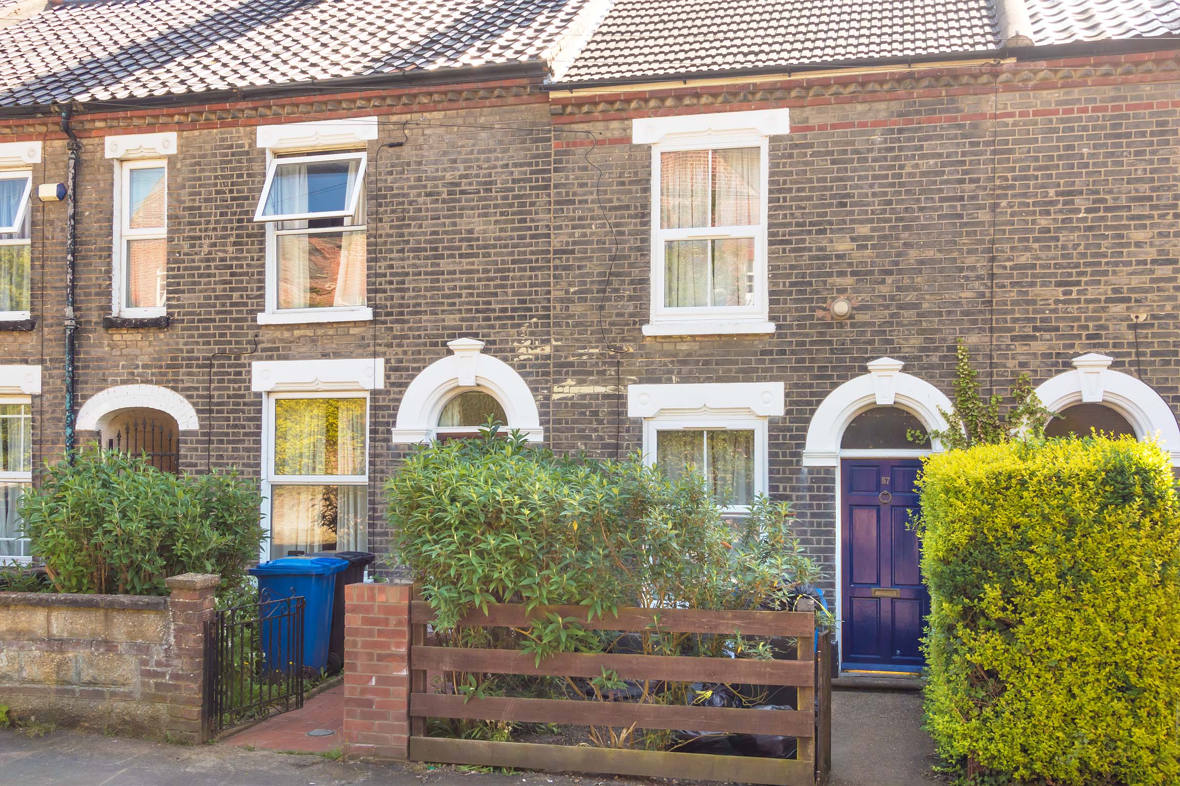 Terraced brick house with wooden purple door.