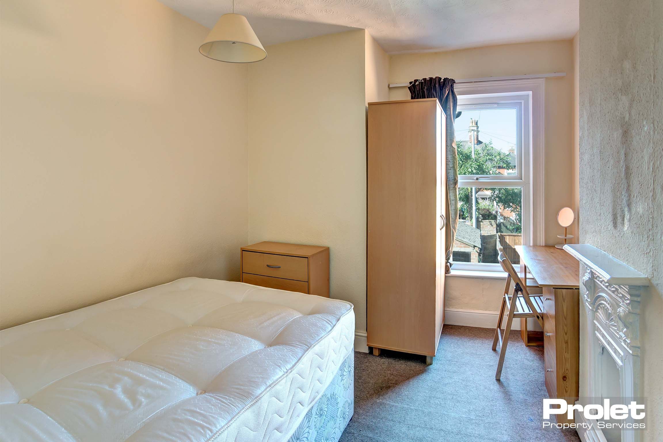 Bedroom with double bed and wood effect furnishings