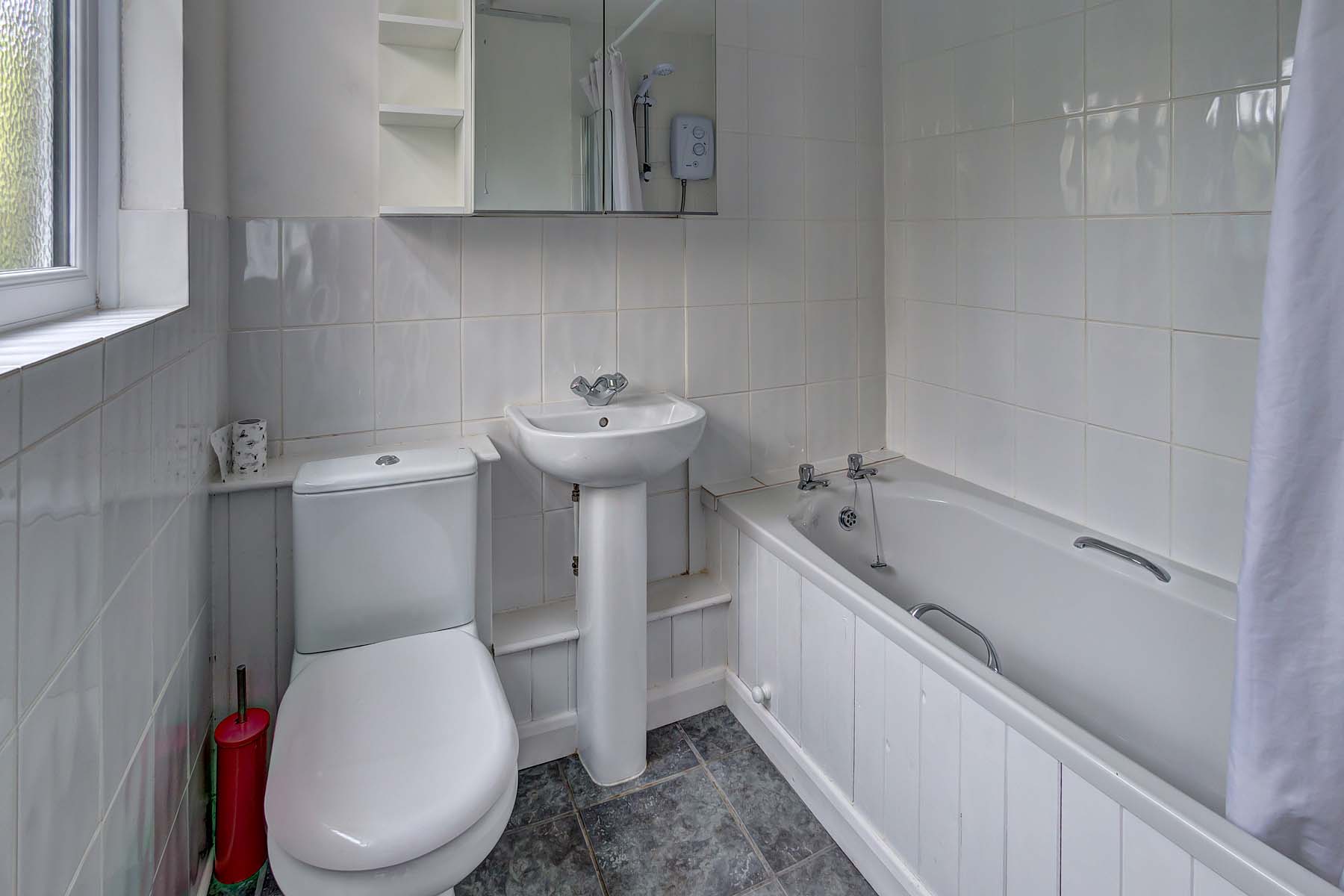 Bathroom with shower over bath, toilet, and sink