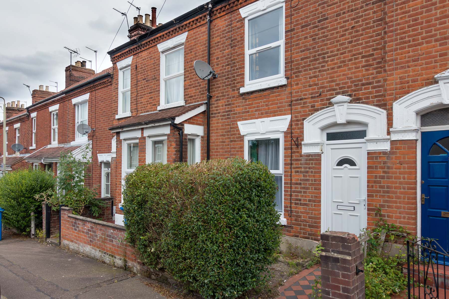 Red brick terraced house with white UPCV door