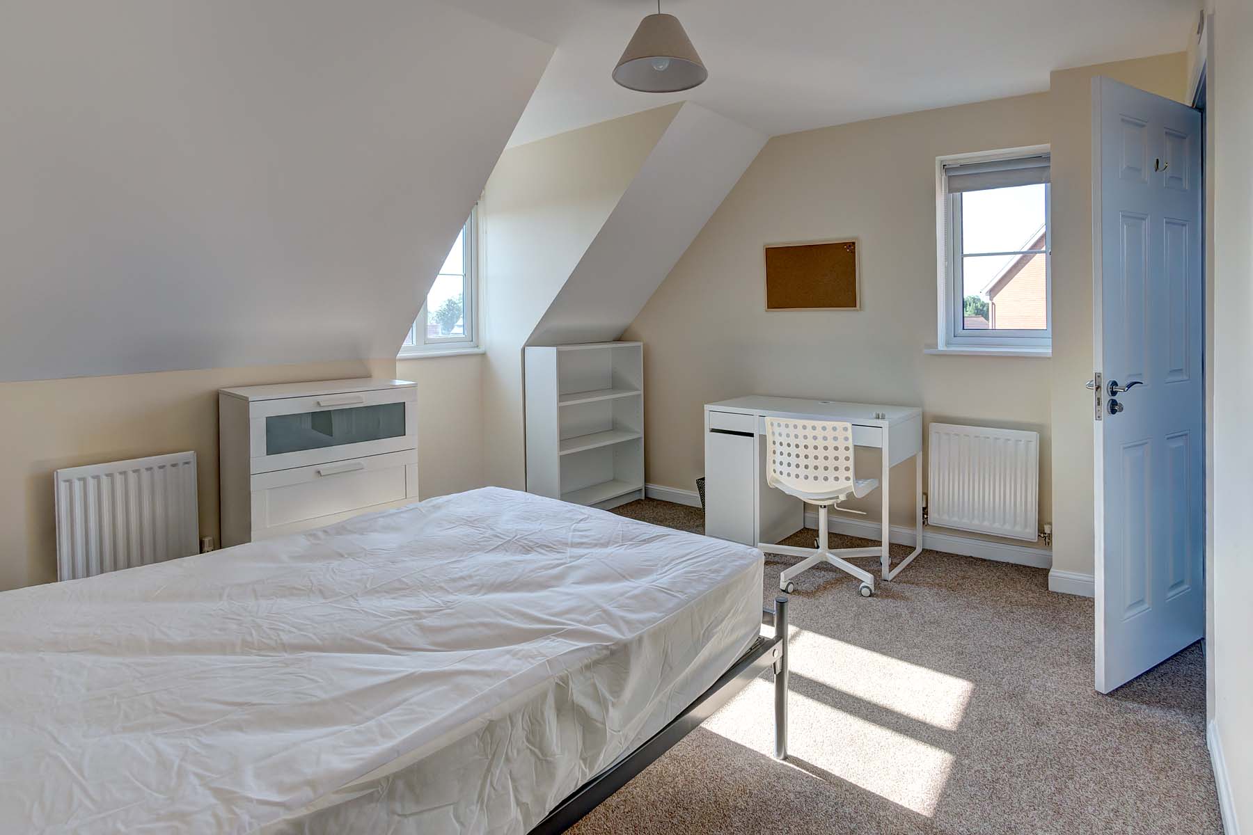 Attic room with double bed and white furnishings