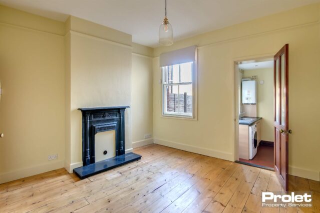 Buttermilk walls with stripped floorboards and feature fireplace