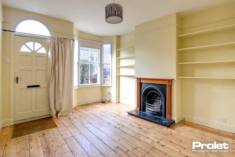 Buttermilk walls with stripped floorboards and feature fireplace