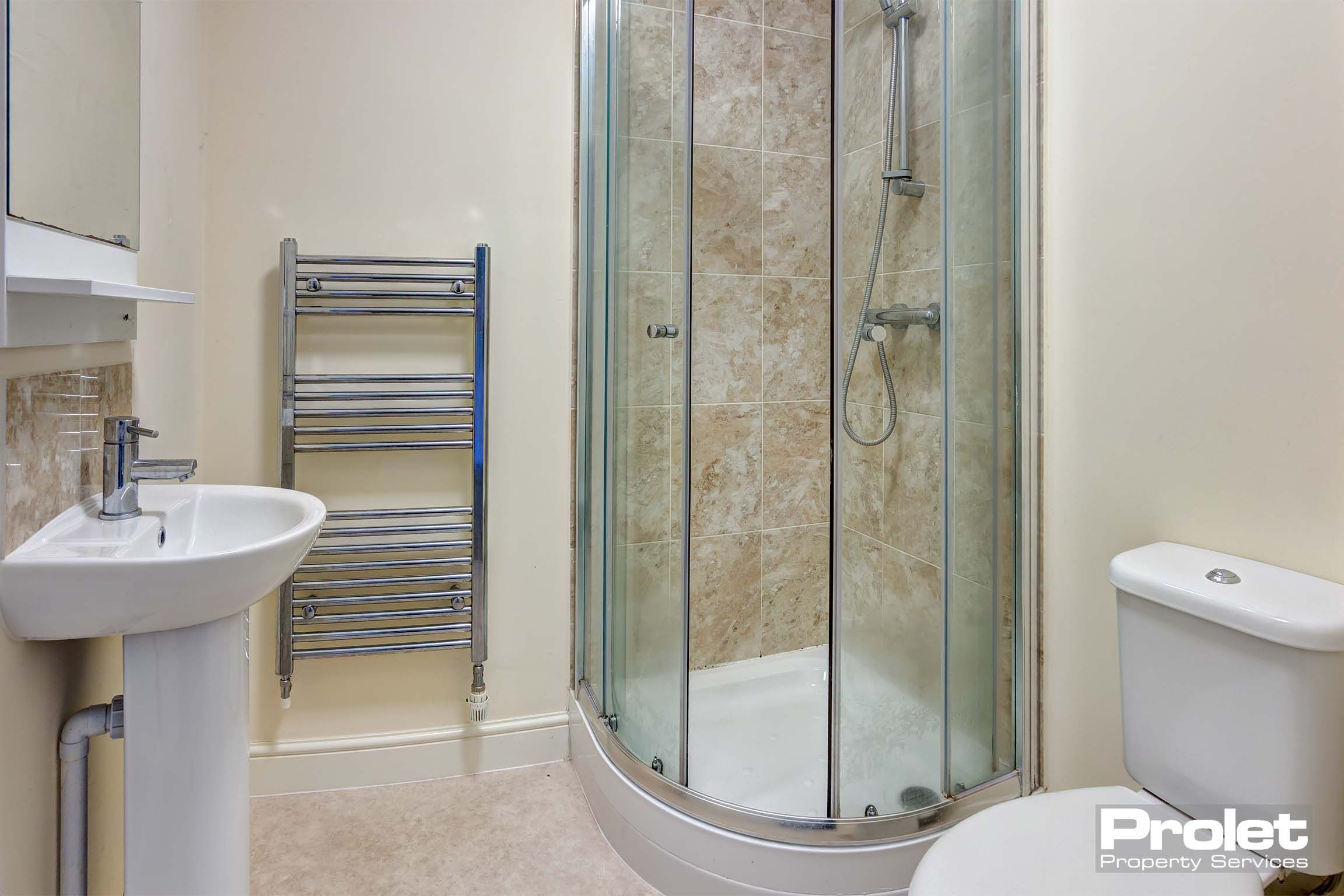 Bathroom with toilet, sink, shower cubicle, and towel warmer