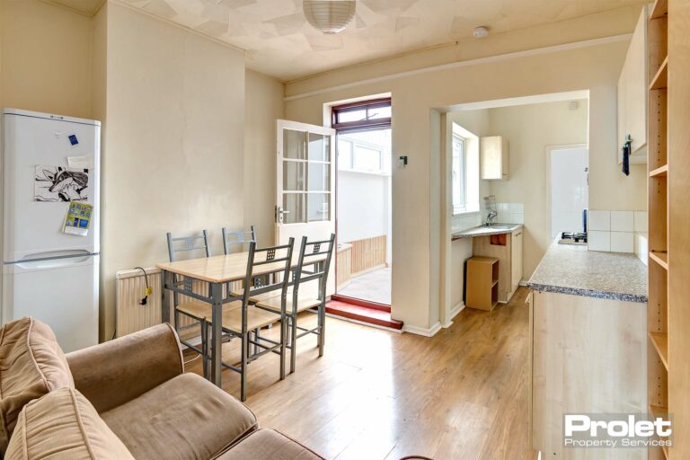 Open planned kitchen and dining area. Dining set and white goods