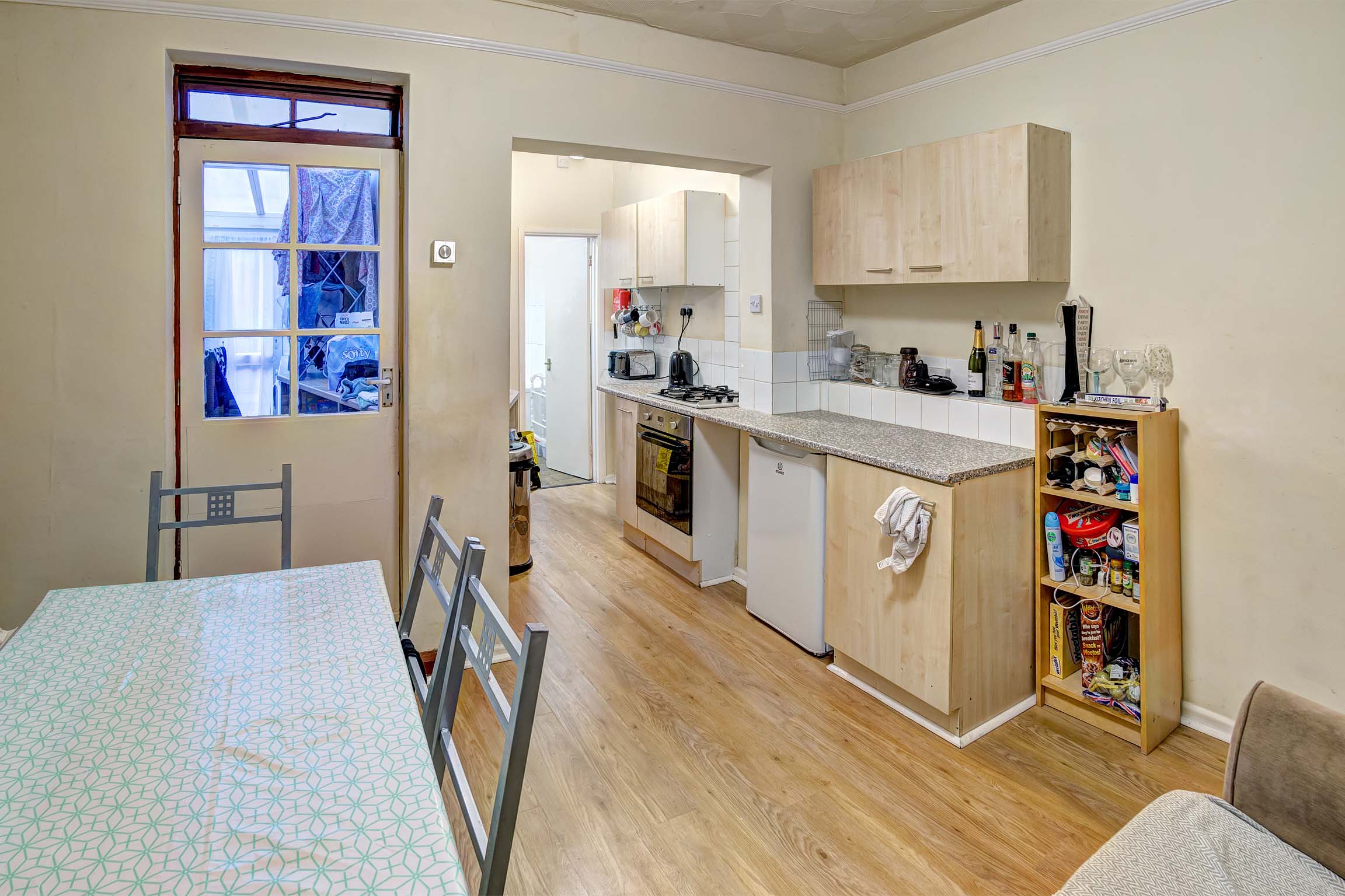 Open planned kitchen and dining area. Dining set and white goods