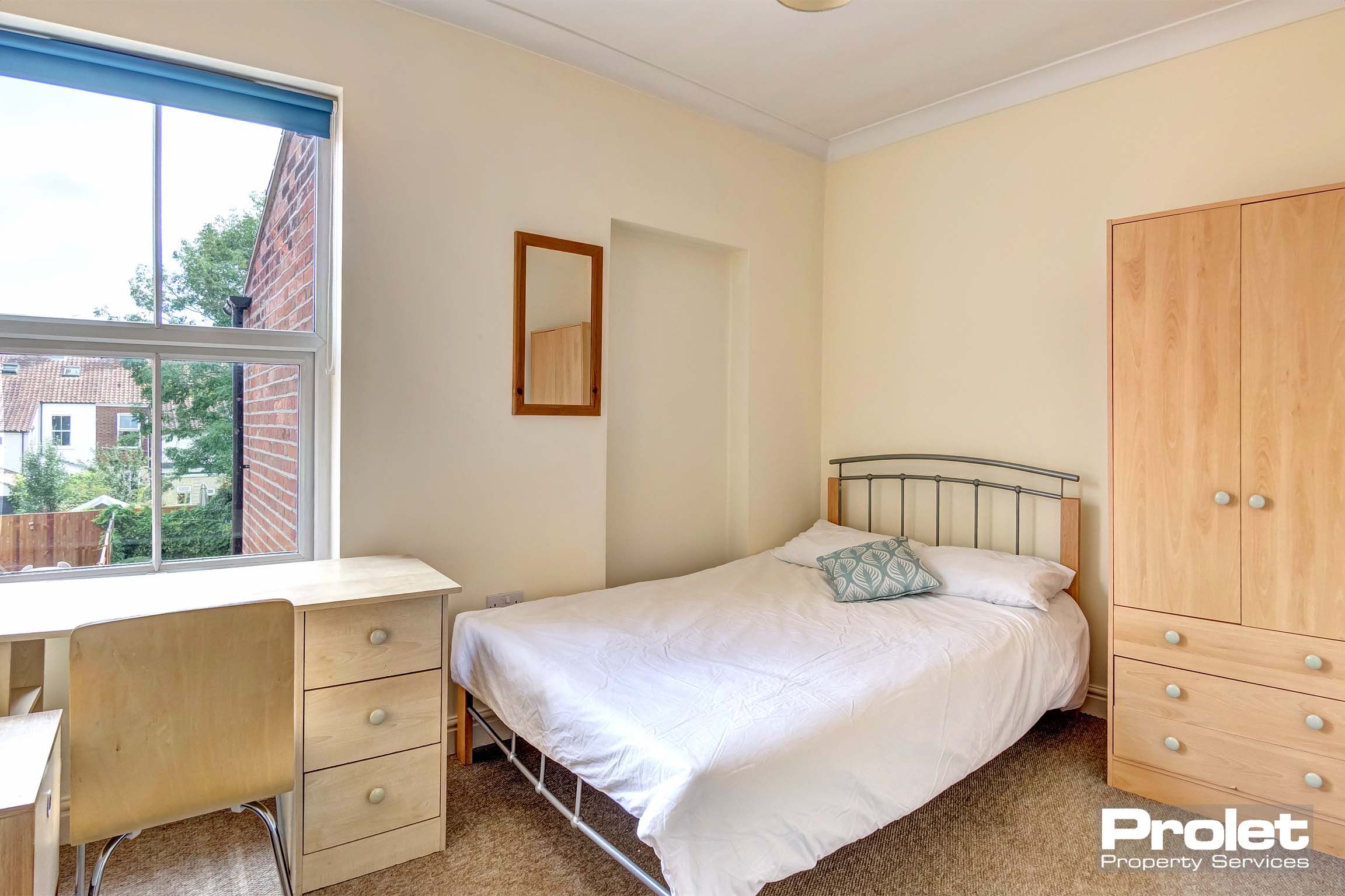 Bedroom with double bed and wood effect furnishings