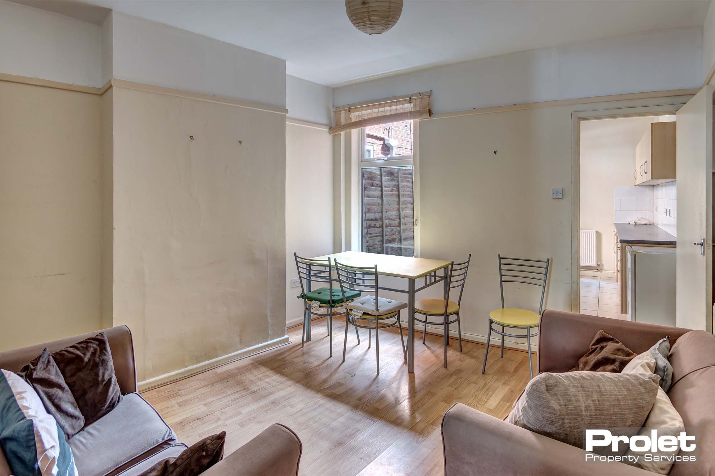 Living room with hardwood floor, sofas, and dining set