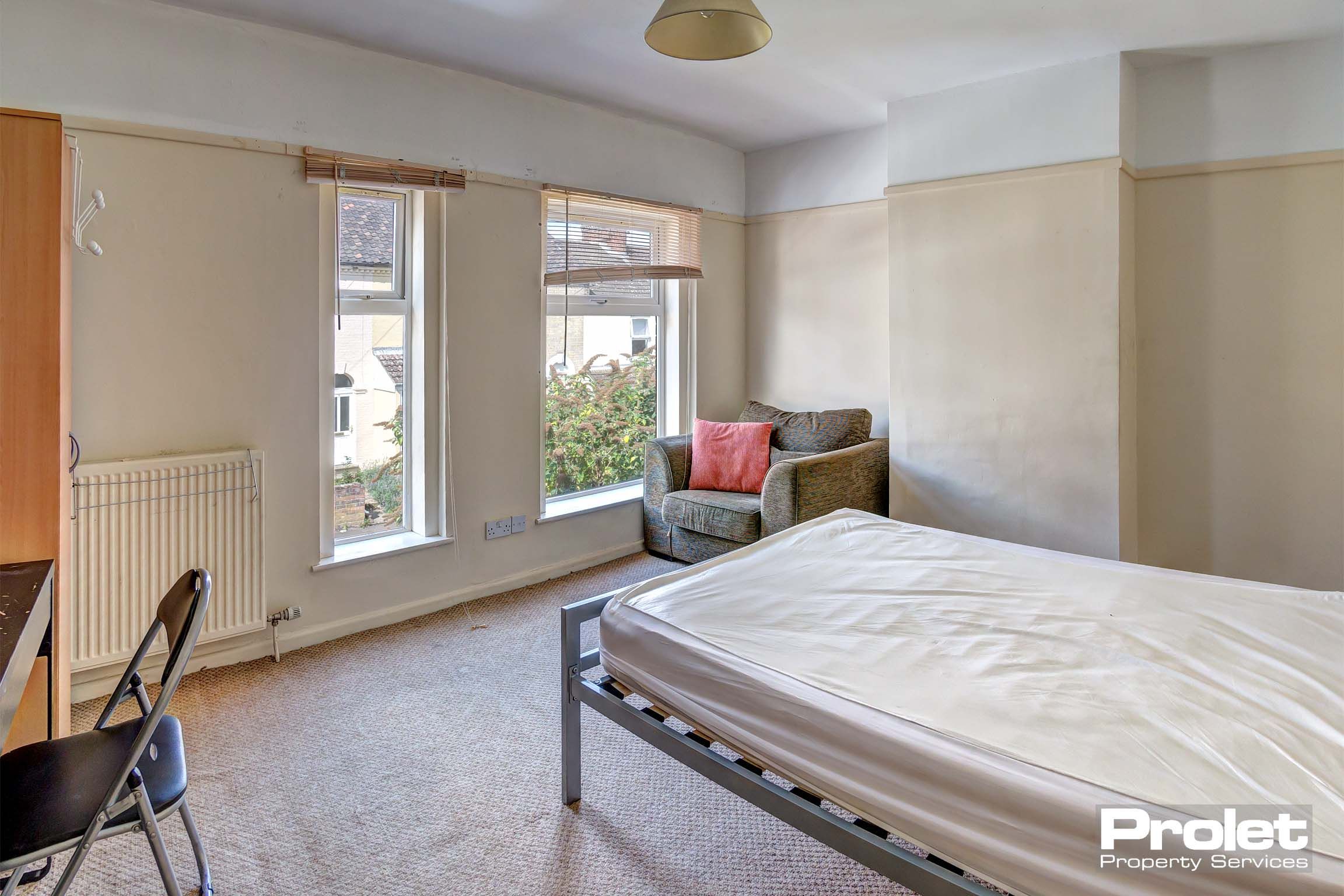 Bedroom with double bed and armchair