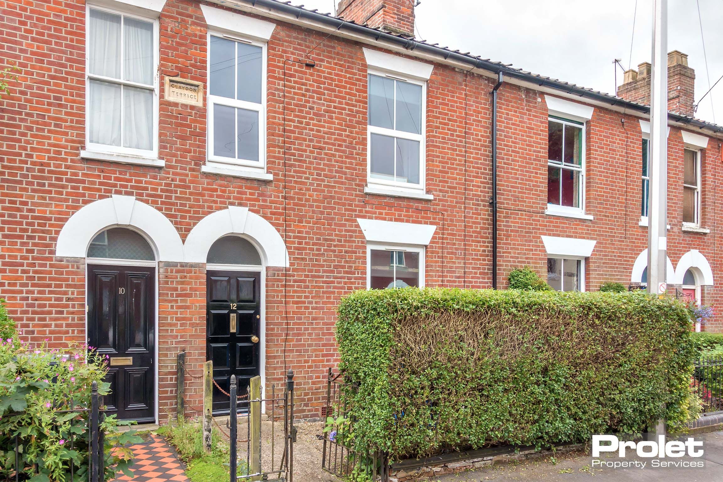 Red brick terraced house with black front door