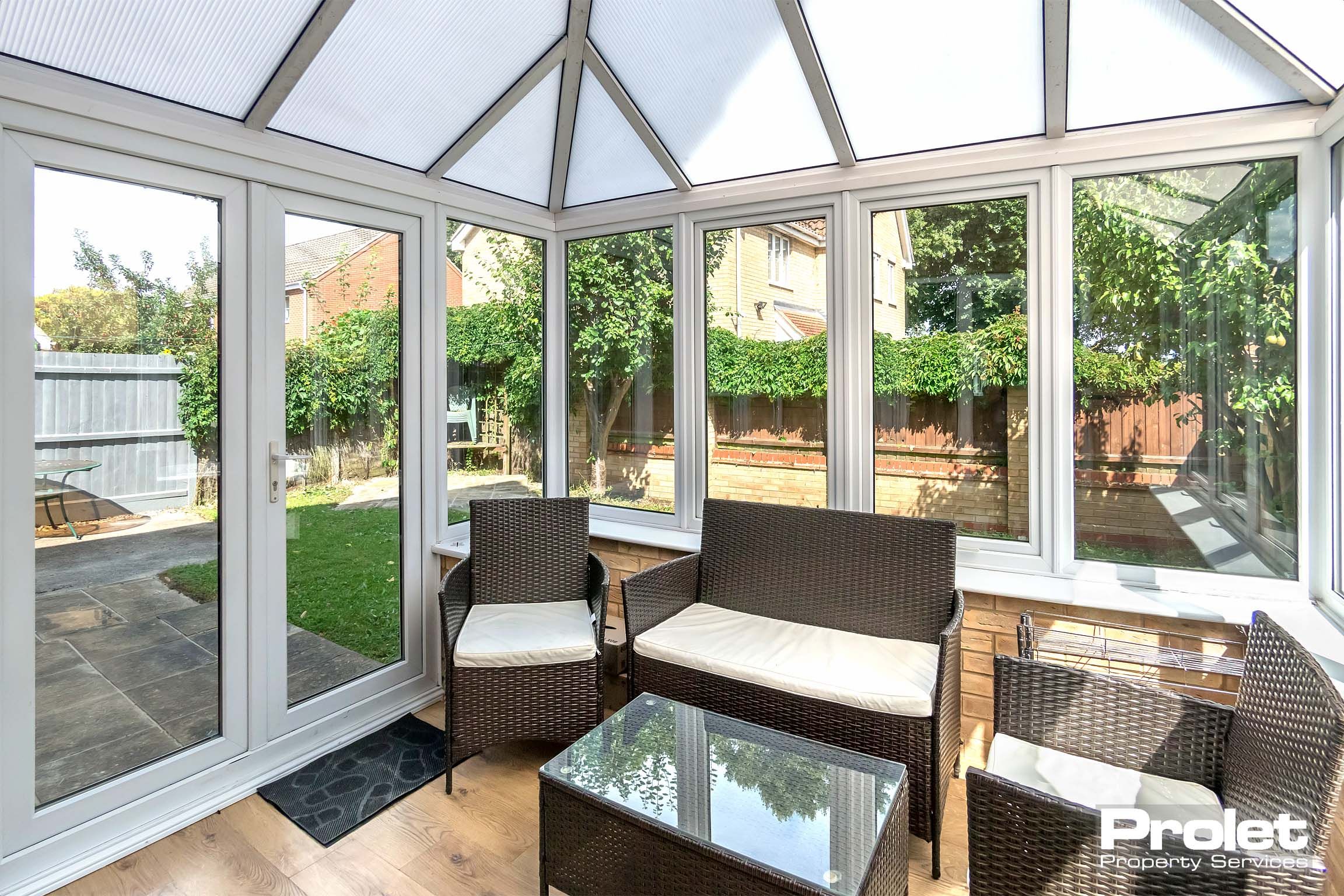 Conservatory/garden room with outdoor style seating and table.