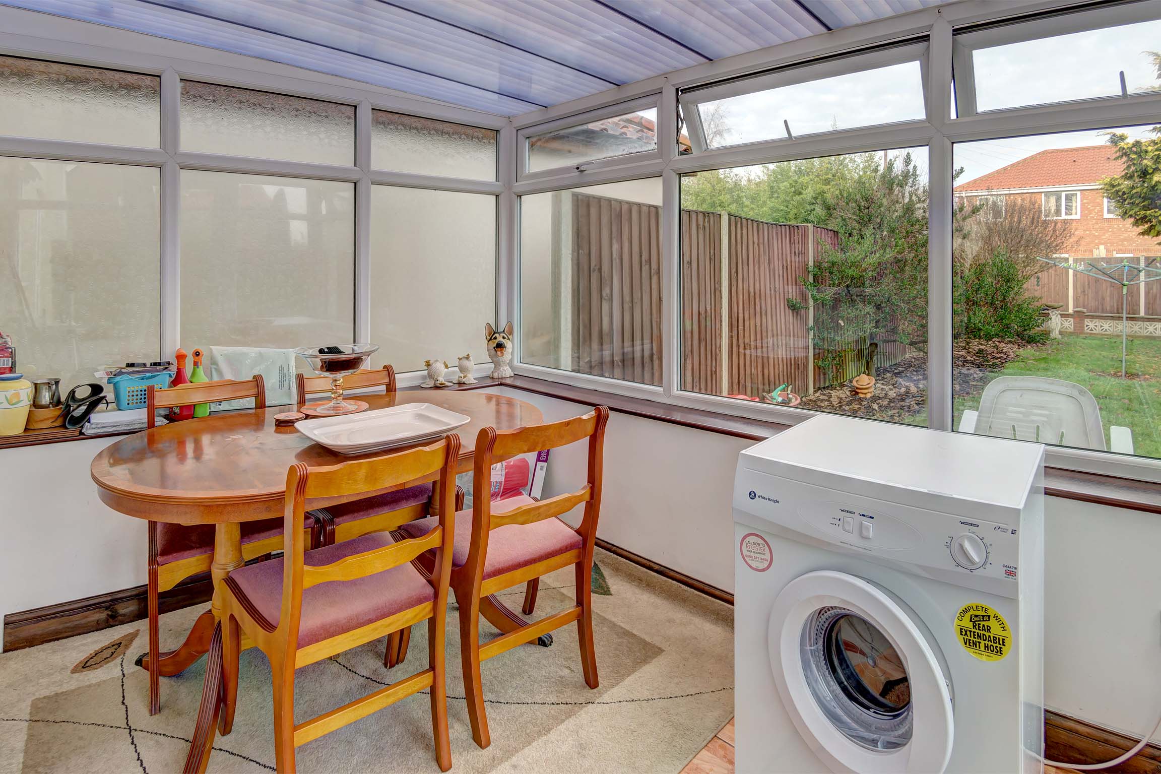 Conservatory with dining table and chars and tumble dryer