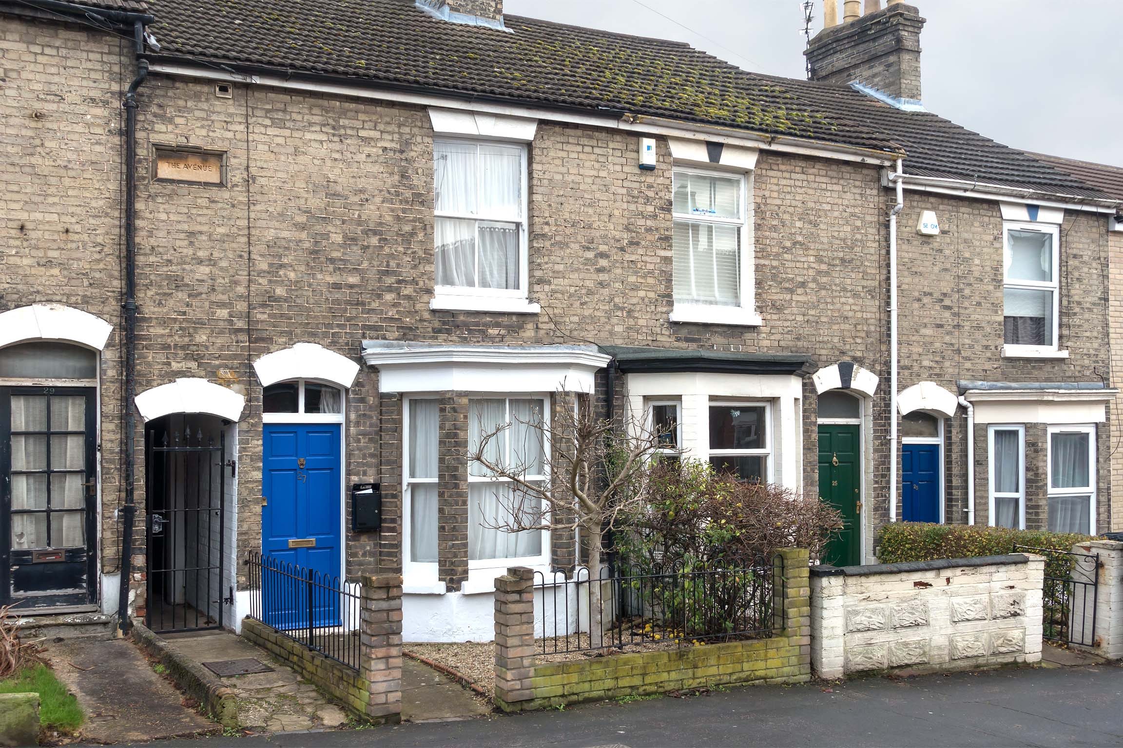 Brick terraced house with dark blue front door.