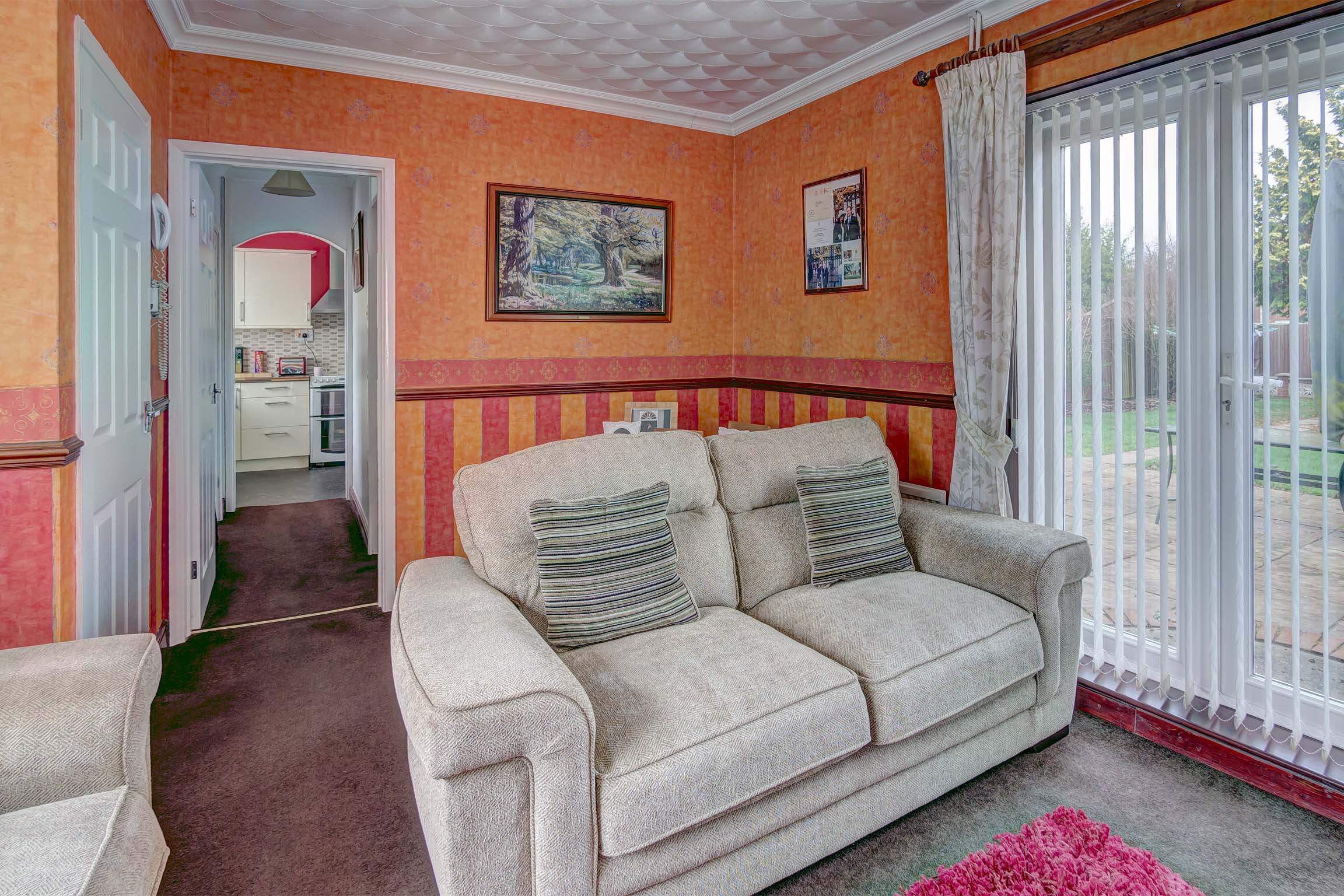 Living room with orange wall paper and white sofa