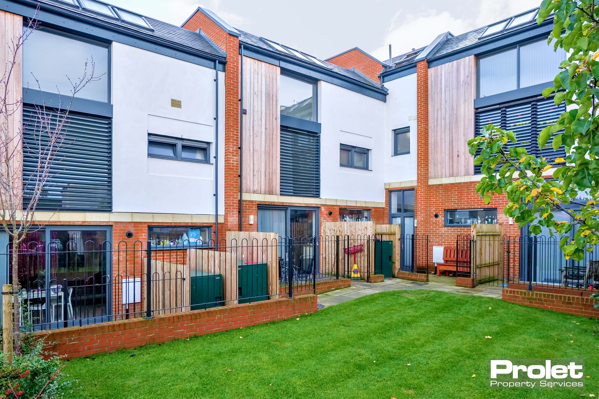 Rear view of townhouse with garden space