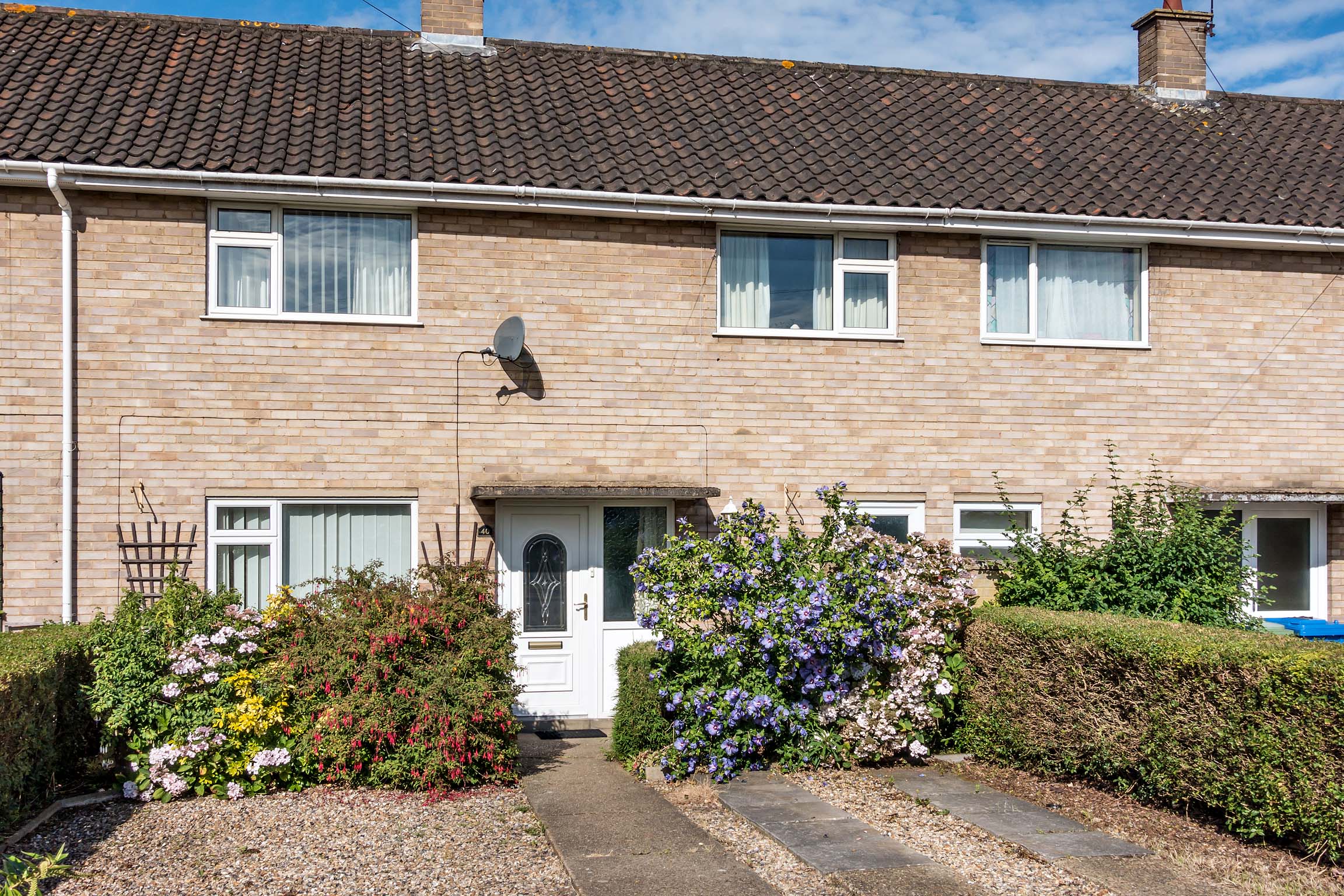 Light coloured brick terraced house.