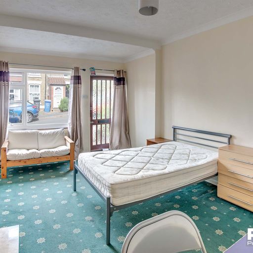 Downstairs bedroom with bay window, double bed, sofa, and furnishings