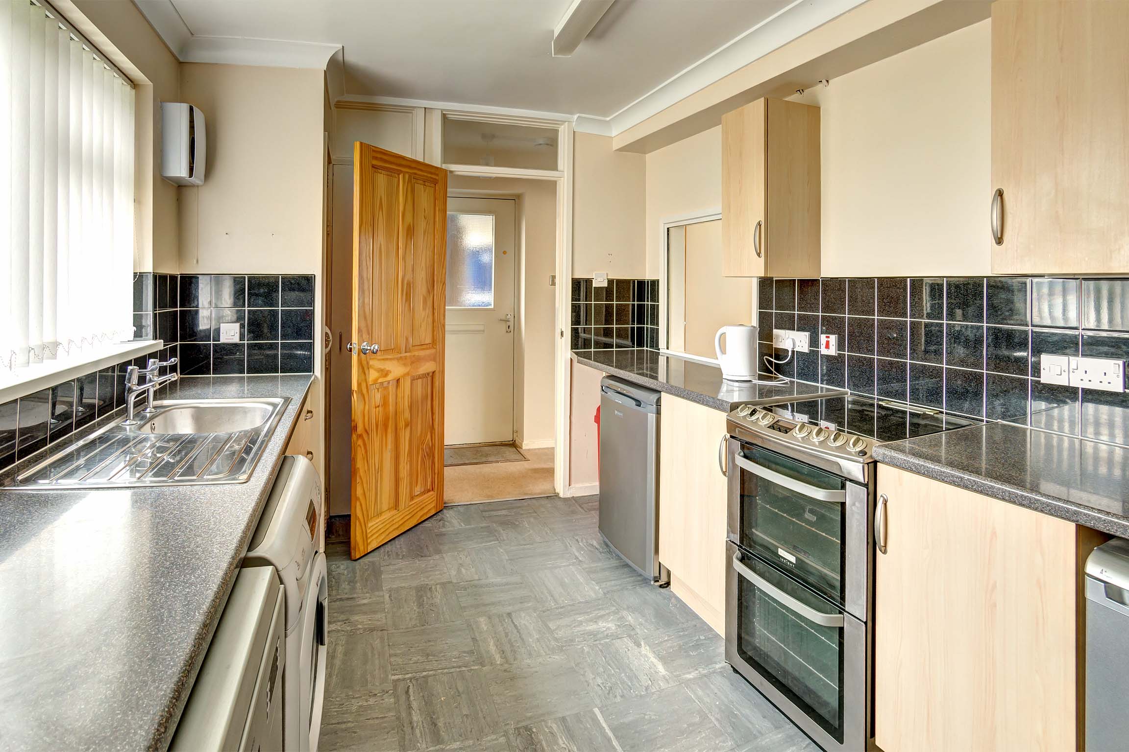 Kitchen with oven, under the counter fridge/freezer, washing machine.