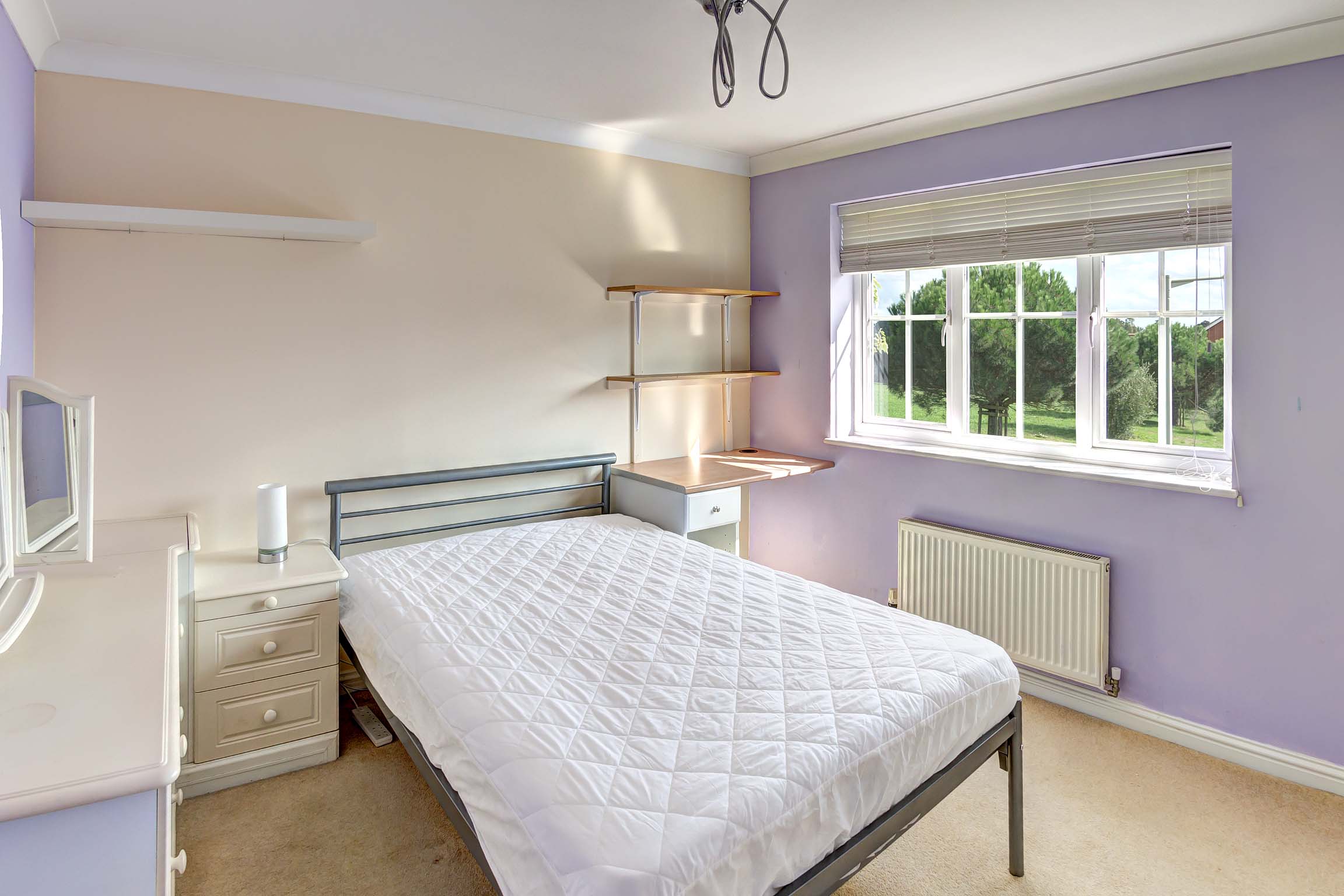 Bedroom with purple walls and shelving