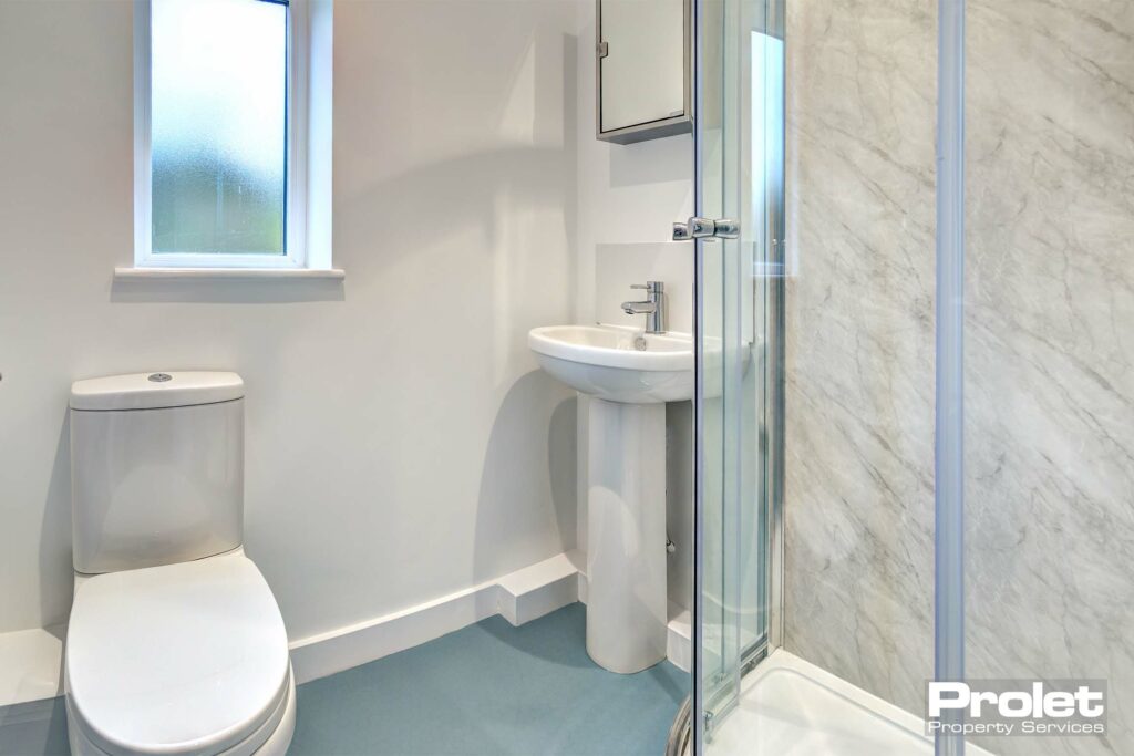 Ensuite bathroom with a glass walk in shower, a white toilet and sink.