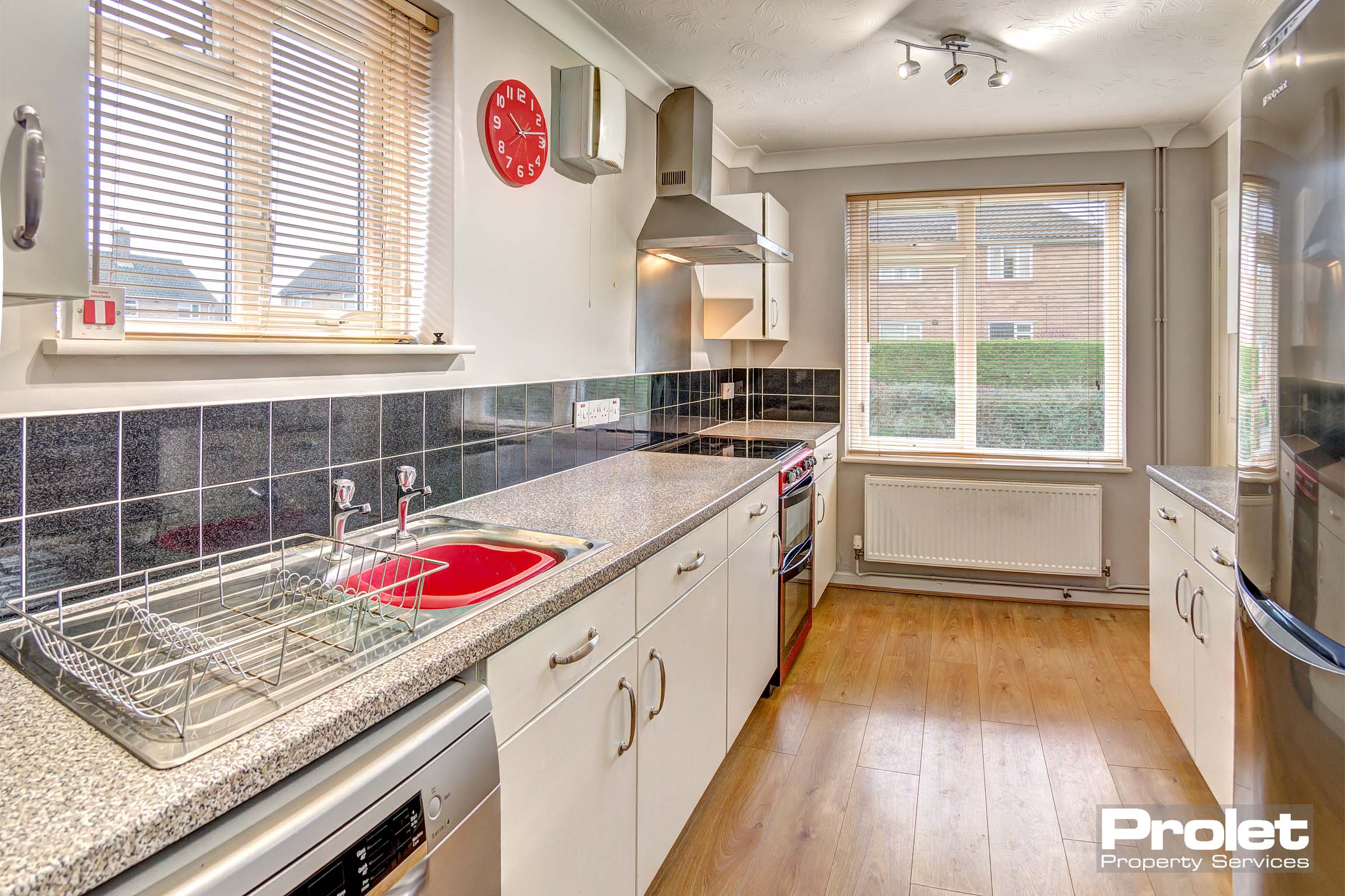 White fitted kitchen with oven and sink