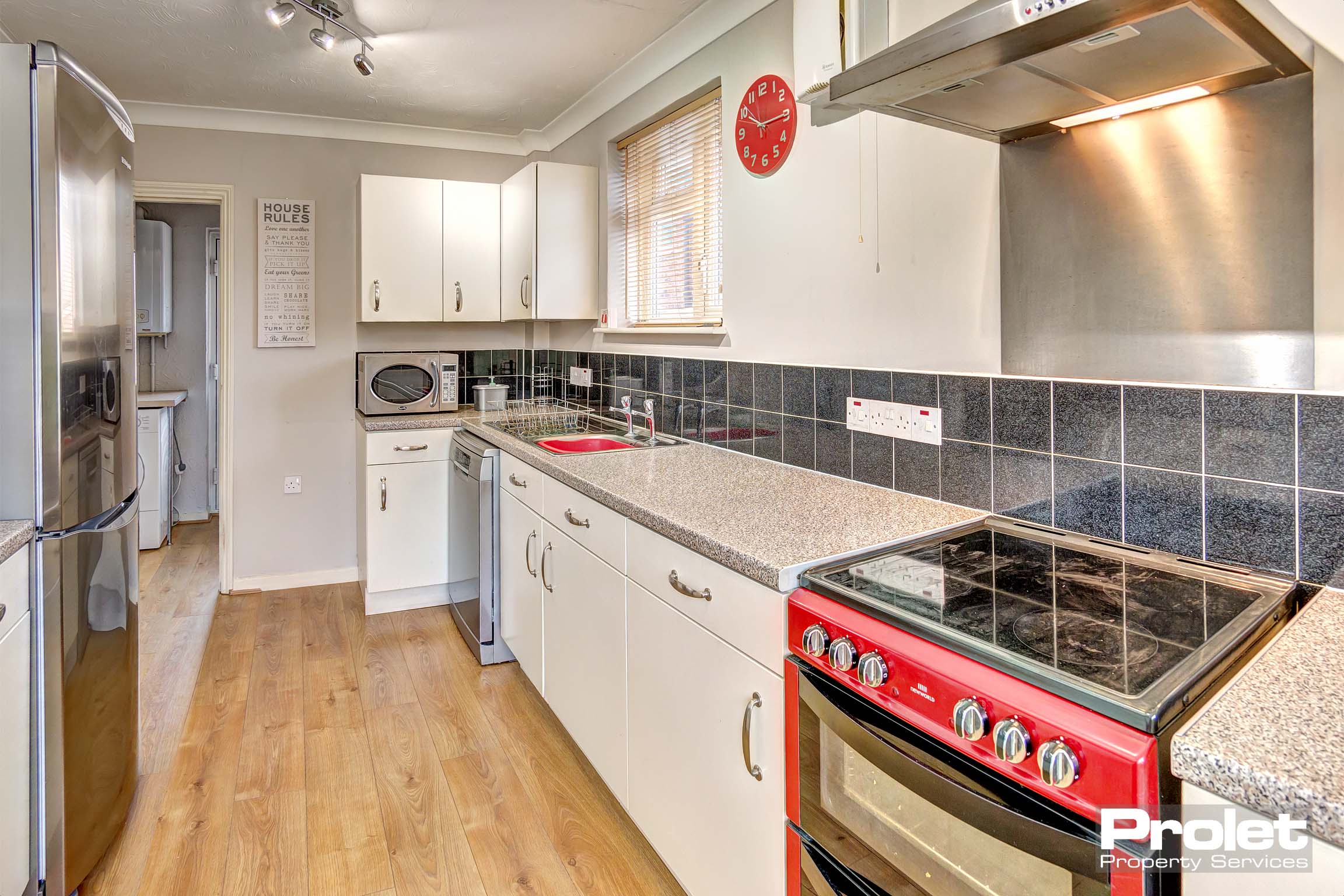 White fitted kitchen with red oven