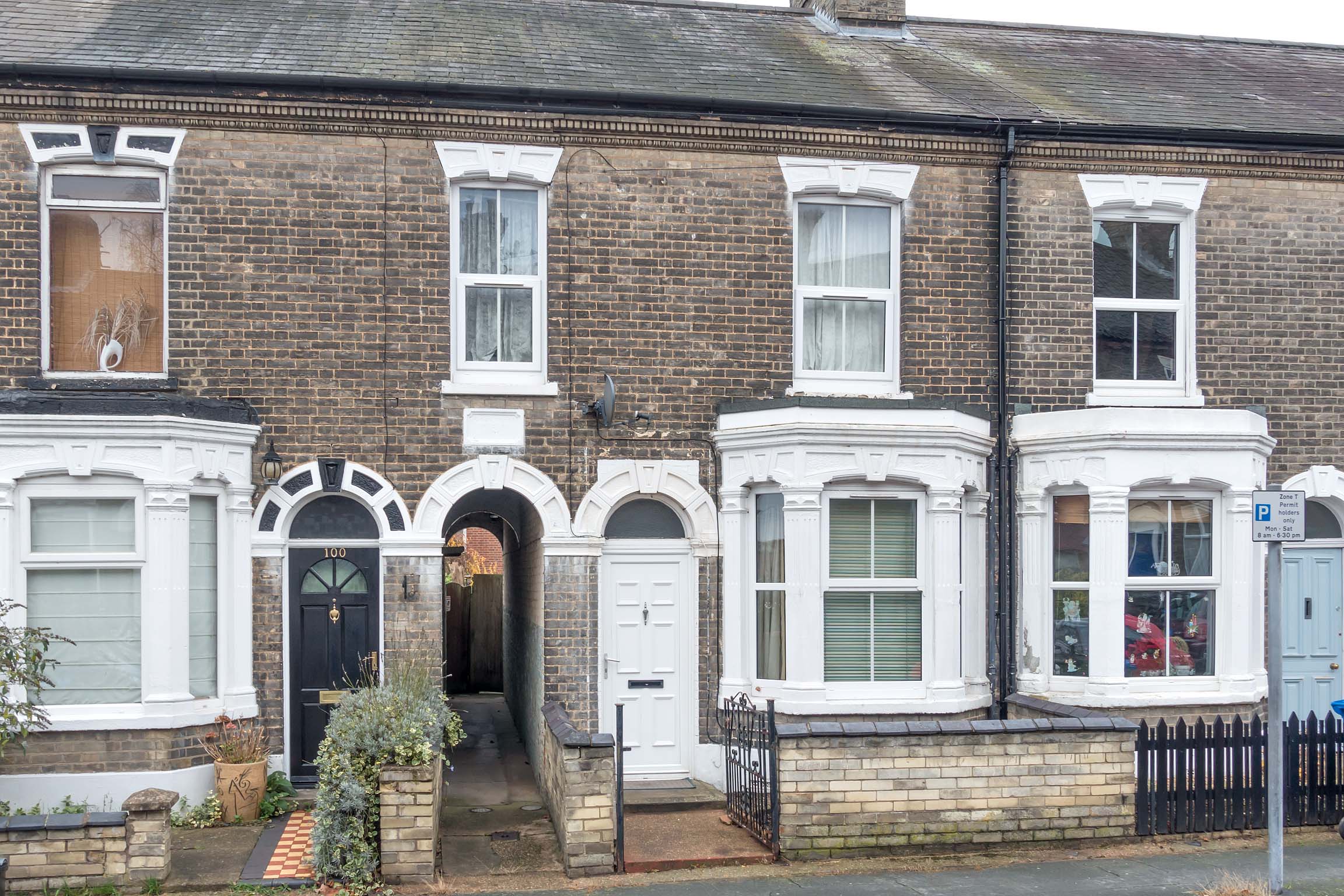 Grey brick Victorian terrace with white door and windows