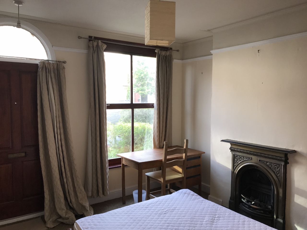 Bedroom with double bed, desk, and period fireplace