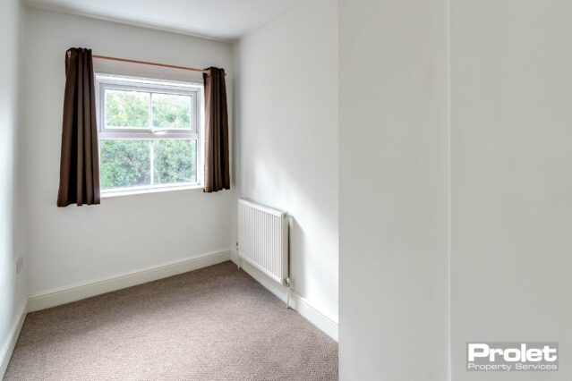 Bedroom at rear left of the property off landing with white walls and light brown carpet. Window overlooking rear garden with brick shed.