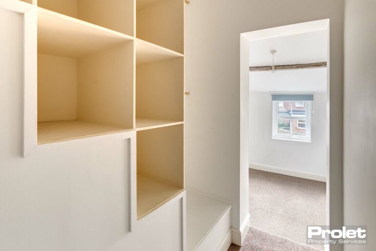 Shelving area and hanging rail in entrance to back bedroom.