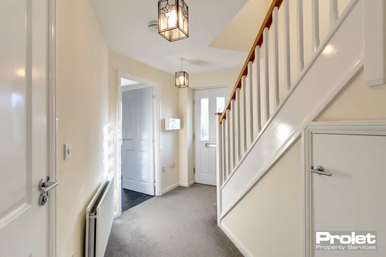 Wooden stair banisted with magnolia walls and grey carpet